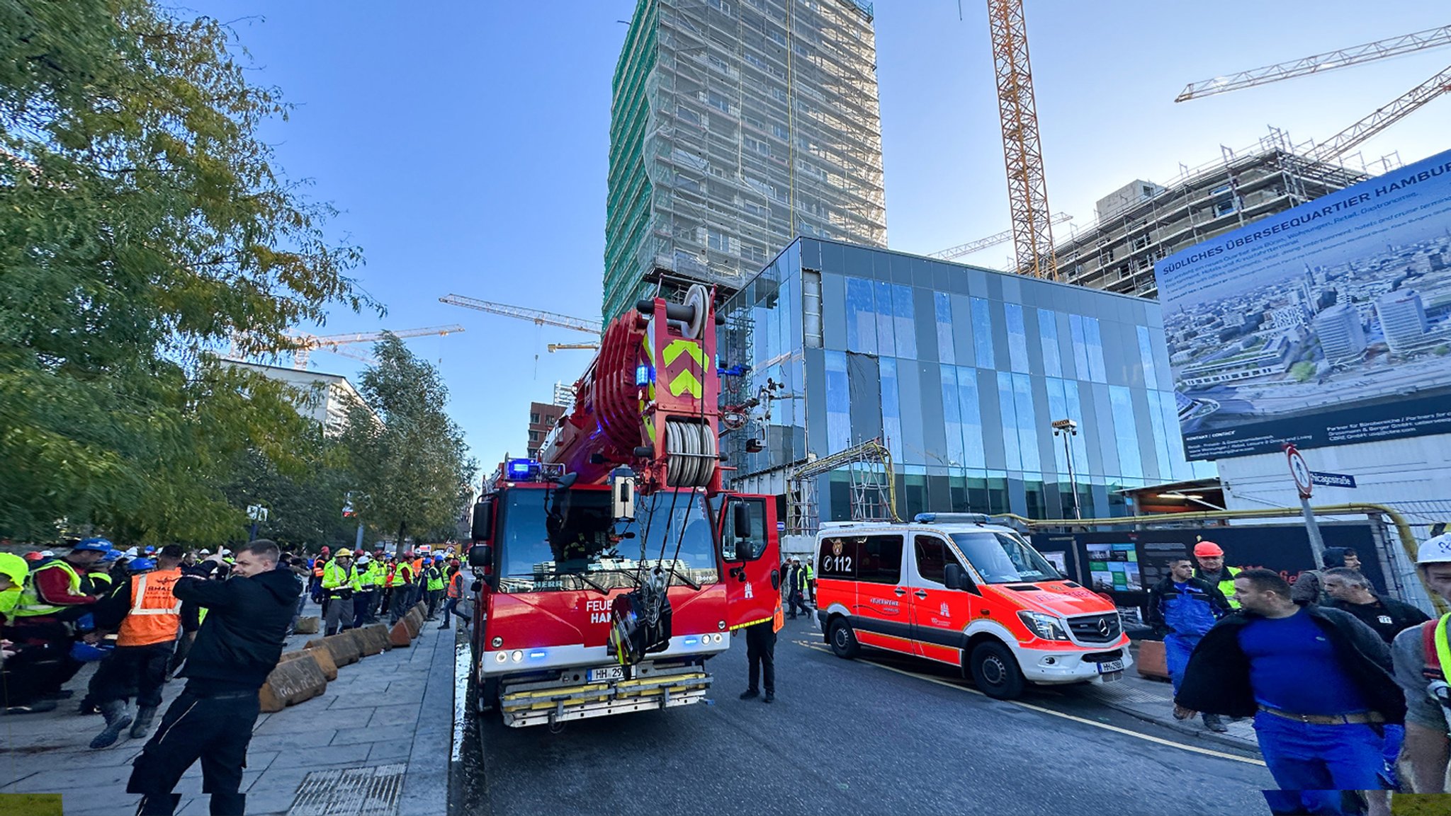 Rettungskräfte und Bauarbeiter stehen am Ort des tödlichen Unfalls in Hamburg