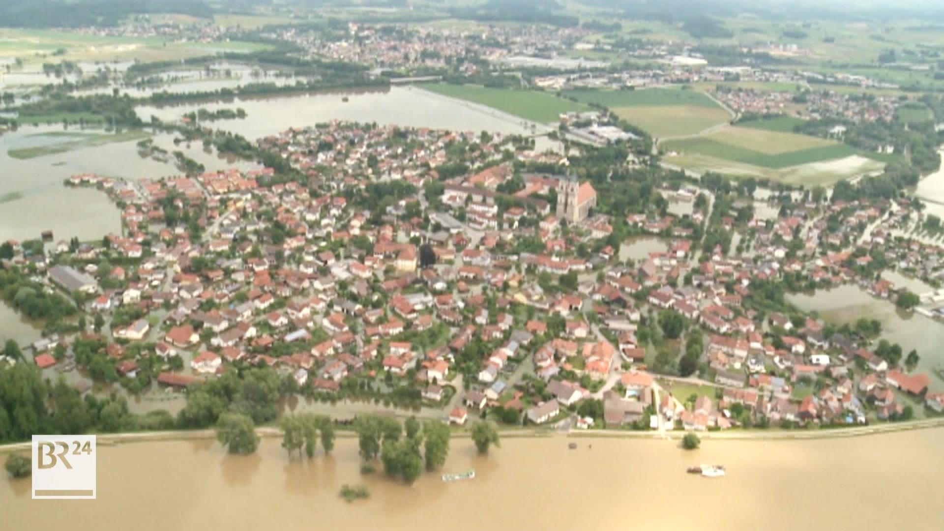 Neue Höchstwerte bei den WasserständenTeils werden neue Rekord-Wasserstände erreicht. Von "Hochwasser XXL" oder "Hochwasser extrem" spricht etwa der Pfaffenhofener Einsatzleiter und Kreisbrandrat Christian Nitschke, als er im BR erklärt, es gehe jetzt darum, Leben zu retten, Sachwerte dürften demgegenüber keine Rolle spielen. Das sogenannte HQ extrem übersteigt noch das sogenannte HQ100, das ein Hochwasser bezeichnet, das im statistischen Mittel einmal in 100 Jahren erreicht oder überschritten wird: "Ein unberechenbares Hochwasser", das es so seit Beginn der Aufzeichnungen nicht gegeben habe, erklärt er weiter: "Der Markt Reichertshofen wird aktuell überflutet. Wir können nichts mehr tun." Selbst ein Teil des Krisenstabs ist zeitweise eingeschlossen. Habeck und Söder im KatastrophengebietVizekanzler Robert Habeck (Grüne) und Ministerpräsident Markus Söder (CSU) sind hier noch am Mittag vor Ort gewesen, um sich zusammen mit dem bayerischen Innenminister Joachim Herrmann ein Bild der katastrophalen Hochwasserlage zu machen. Kurz vor ihrem Eintreffen in Reichertshofen ist unweit davon in der Nachbargemeinde Baar-Ebenhausen ein Damm gebrochen; in der Folge wurde mit dem Umspannwerk Reichertshofen kritische Infrastruktur überflutet und Strom und Internet für tausende Menschen fielen aus. Der Damm, der eigentlich das Flüsschen Paar einhegen sollte, einen Nebenfluss der Donau, ist gleich an zwei Stellen gebrochen und konnte nicht repariert werden. Es folgen Überflutungen und Evakuierungen. Rund 5.000 Einsatzkräfte kämpften im Landkreis Pfaffenhofen gegen die Fluten und halfen, Menschen zu retten.Feuerwehrmann im Rettungseinsatz ums Leben gekommenIn der Nacht war ein Feuerwehrmann bei einer Rettungsaktion ums Leben gekommen. Die Politiker äußerten sich zutiefst betroffen von dem Todesfall. "Auf dem Weg nach Pfaffenhofen erfahre ich von dem Tod eines Feuerwehrmannes. Es ist furchtbar. Er starb, als er Menschen vor dem Hochwasser retten wollte", sagte Habeck. Ähnlich äußerte sich Söder. Der 42 Jahre alte Mann der Freiwilligen Feuerwehr war bei dem Einsatz mit drei Kollegen mit dem Schlauchboot gekentert und am frühen Morgen tot geborgen worden. Ein anderer Feuerwehrmann wird noch immer im Kreis Günzburg vermisst. Im Landkreis Neuburg-Schrobenhausen starb eine 43-jährige Frau. Sie wurde vom Hochwasser im Keller eines Mehrfamilienhauses überrascht.In Allershausen im Landkreis Freising ist durch Stromschlag ein 27 Jahre alter Beschäftigter eines Energieunternehmens lebensgefährlich verletzt worden. Viele helfen unter Einsatz ihres eigenen Lebens, Menschenleben zu retten. Hubschrauber knattern über den überschwemmten Gebieten. An Seilwinden holen die Crews Menschen aus Häusern, die anders nicht mehr zugänglich sind, etwa in Babenhausen im Unterallgäu. Das Wasser sei einfach immer weiter geströmt - "Wir hatten keine Chance mehr", erklärt ein Anwohner, der den Fluten entkommen konnte. In Allershausen musste wegen der Hochwasserlage im Ortsteil Göttschlag der Strom vorsorglich abgeschaltet werden.