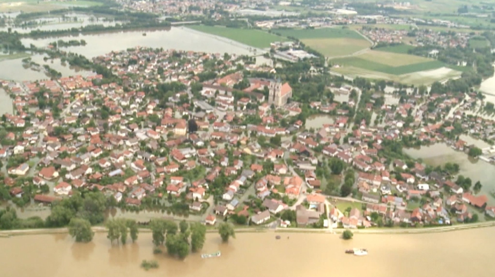 Neue Höchstwerte bei den WasserständenTeils werden neue Rekord-Wasserstände erreicht. Von "Hochwasser XXL" oder "Hochwasser extrem" spricht etwa der Pfaffenhofener Einsatzleiter und Kreisbrandrat Christian Nitschke, als er im BR erklärt, es gehe jetzt darum, Leben zu retten, Sachwerte dürften demgegenüber keine Rolle spielen. Das sogenannte HQ extrem übersteigt noch das sogenannte HQ100, das ein Hochwasser bezeichnet, das im statistischen Mittel einmal in 100 Jahren erreicht oder überschritten wird: "Ein unberechenbares Hochwasser", das es so seit Beginn der Aufzeichnungen nicht gegeben habe, erklärt er weiter: "Der Markt Reichertshofen wird aktuell überflutet. Wir können nichts mehr tun." Selbst ein Teil des Krisenstabs ist zeitweise eingeschlossen. Habeck und Söder im KatastrophengebietVizekanzler Robert Habeck (Grüne) und Ministerpräsident Markus Söder (CSU) sind hier noch am Mittag vor Ort gewesen, um sich zusammen mit dem bayerischen Innenminister Joachim Herrmann ein Bild der katastrophalen Hochwasserlage zu machen. Kurz vor ihrem Eintreffen in Reichertshofen ist unweit davon in der Nachbargemeinde Baar-Ebenhausen ein Damm gebrochen; in der Folge wurde mit dem Umspannwerk Reichertshofen kritische Infrastruktur überflutet und Strom und Internet für tausende Menschen fielen aus. Der Damm, der eigentlich das Flüsschen Paar einhegen sollte, einen Nebenfluss der Donau, ist gleich an zwei Stellen gebrochen und konnte nicht repariert werden. Es folgen Überflutungen und Evakuierungen. Rund 5.000 Einsatzkräfte kämpften im Landkreis Pfaffenhofen gegen die Fluten und halfen, Menschen zu retten.Feuerwehrmann im Rettungseinsatz ums Leben gekommenIn der Nacht war ein Feuerwehrmann bei einer Rettungsaktion ums Leben gekommen. Die Politiker äußerten sich zutiefst betroffen von dem Todesfall. "Auf dem Weg nach Pfaffenhofen erfahre ich von dem Tod eines Feuerwehrmannes. Es ist furchtbar. Er starb, als er Menschen vor dem Hochwasser retten wollte", sagte Habeck. Ähnlich äußerte sich Söder. Der 42 Jahre alte Mann der Freiwilligen Feuerwehr war bei dem Einsatz mit drei Kollegen mit dem Schlauchboot gekentert und am frühen Morgen tot geborgen worden. Ein anderer Feuerwehrmann wird noch immer im Kreis Günzburg vermisst. Im Landkreis Neuburg-Schrobenhausen starb eine 43-jährige Frau. Sie wurde vom Hochwasser im Keller eines Mehrfamilienhauses überrascht.In Allershausen im Landkreis Freising ist durch Stromschlag ein 27 Jahre alter Beschäftigter eines Energieunternehmens lebensgefährlich verletzt worden. Viele helfen unter Einsatz ihres eigenen Lebens, Menschenleben zu retten. Hubschrauber knattern über den überschwemmten Gebieten. An Seilwinden holen die Crews Menschen aus Häusern, die anders nicht mehr zugänglich sind, etwa in Babenhausen im Unterallgäu. Das Wasser sei einfach immer weiter geströmt - "Wir hatten keine Chance mehr", erklärt ein Anwohner, der den Fluten entkommen konnte. In Allershausen musste wegen der Hochwasserlage im Ortsteil Göttschlag der Strom vorsorglich abgeschaltet werden.