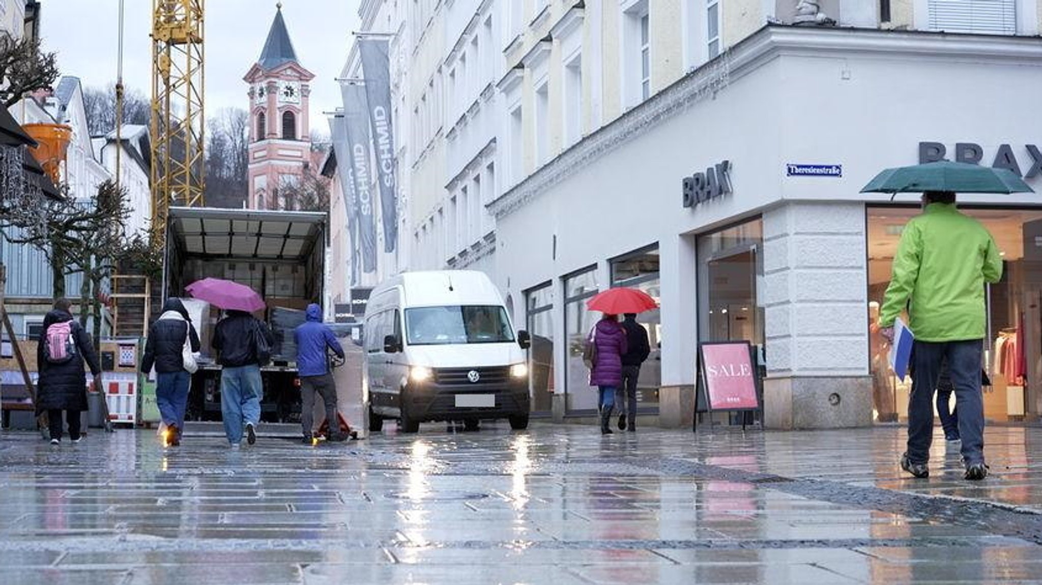 Ein Lieferwagen fährt an einem LKW vorbei, der ausgeladen wird