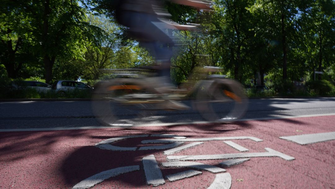 Symbolbild eines Radfahrers auf einem rot markierten Radweg.