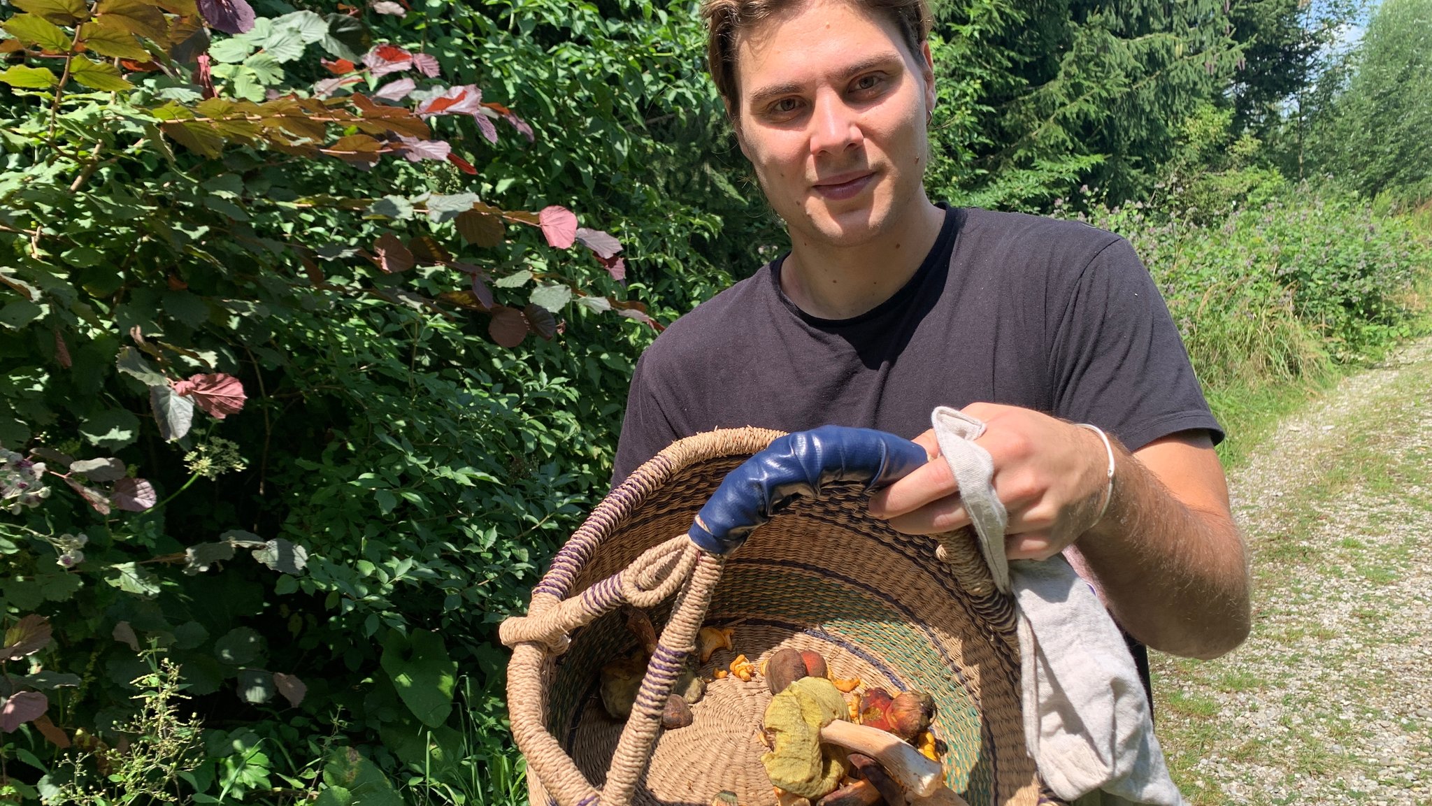 Moritz Feldhege zeigt seinen Korb mit über 60 Pilzen, die er innerhalb einer Stunde in einem Waldstück bei München gefunden hat..