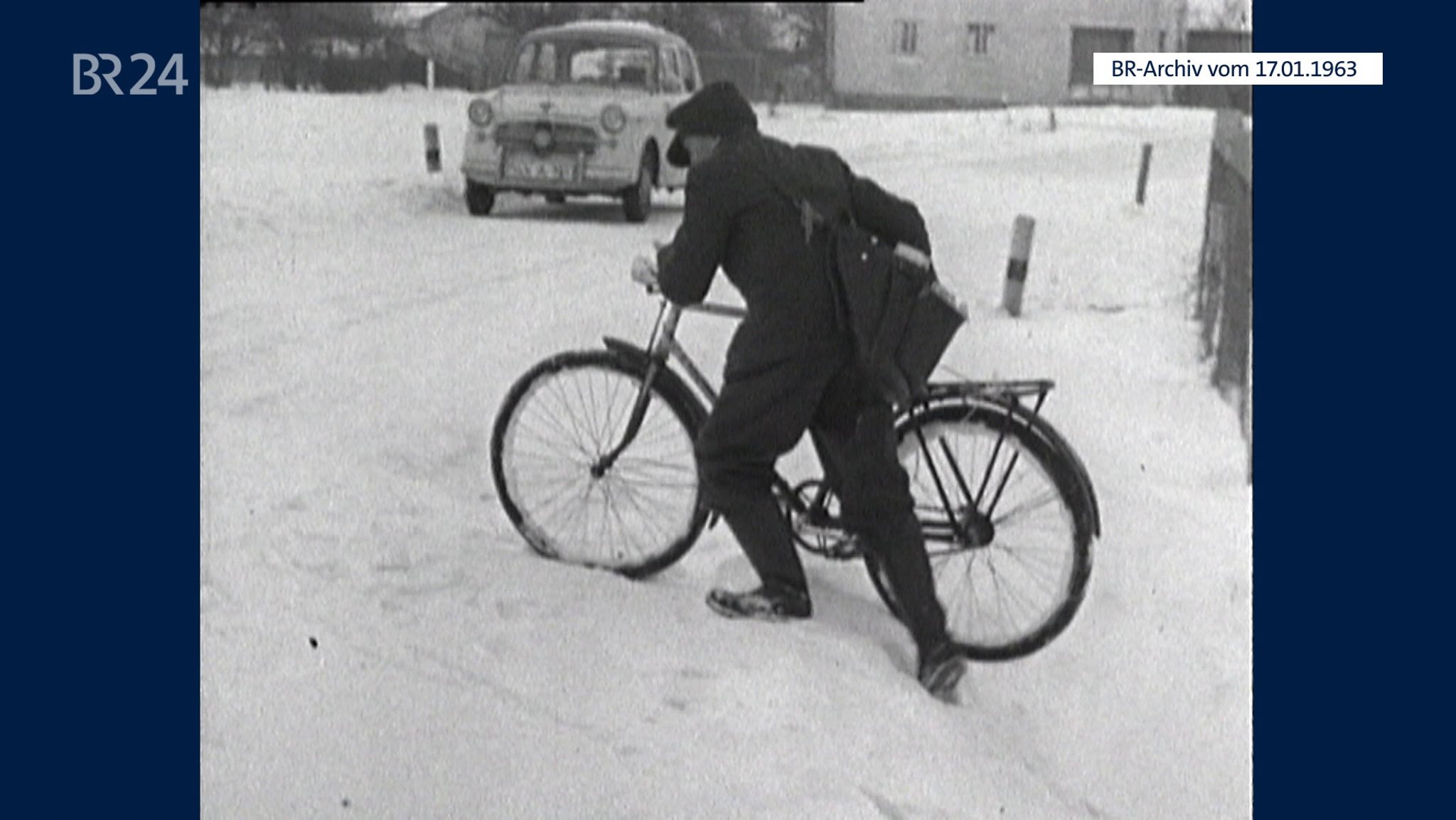 Briefträger mit Fahrrad im Schnee