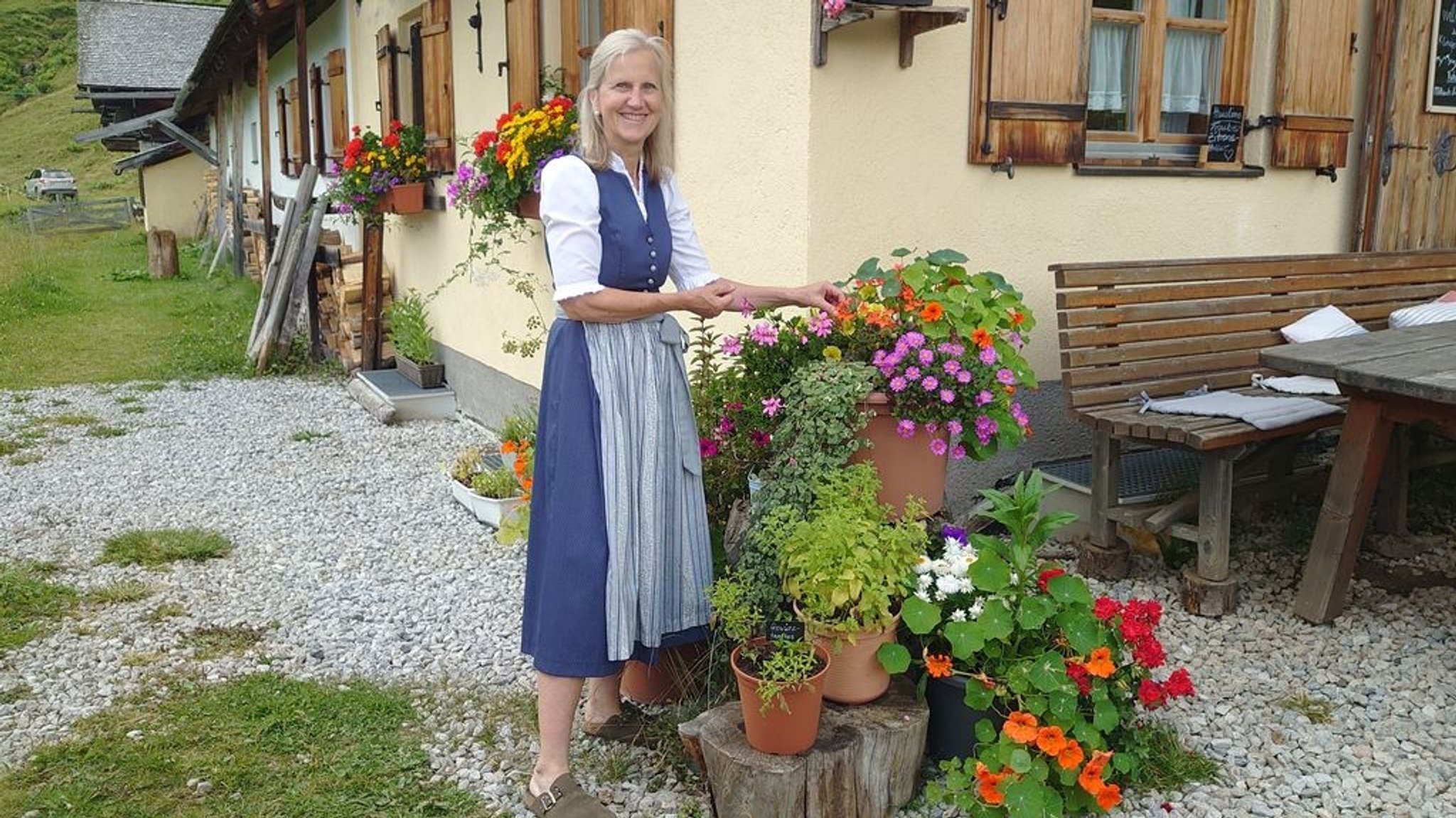 Almwirtin Regina Leybold steht vor den Blumenkästen, die sie vor der Hütte jedes Jahr bepflanzt..