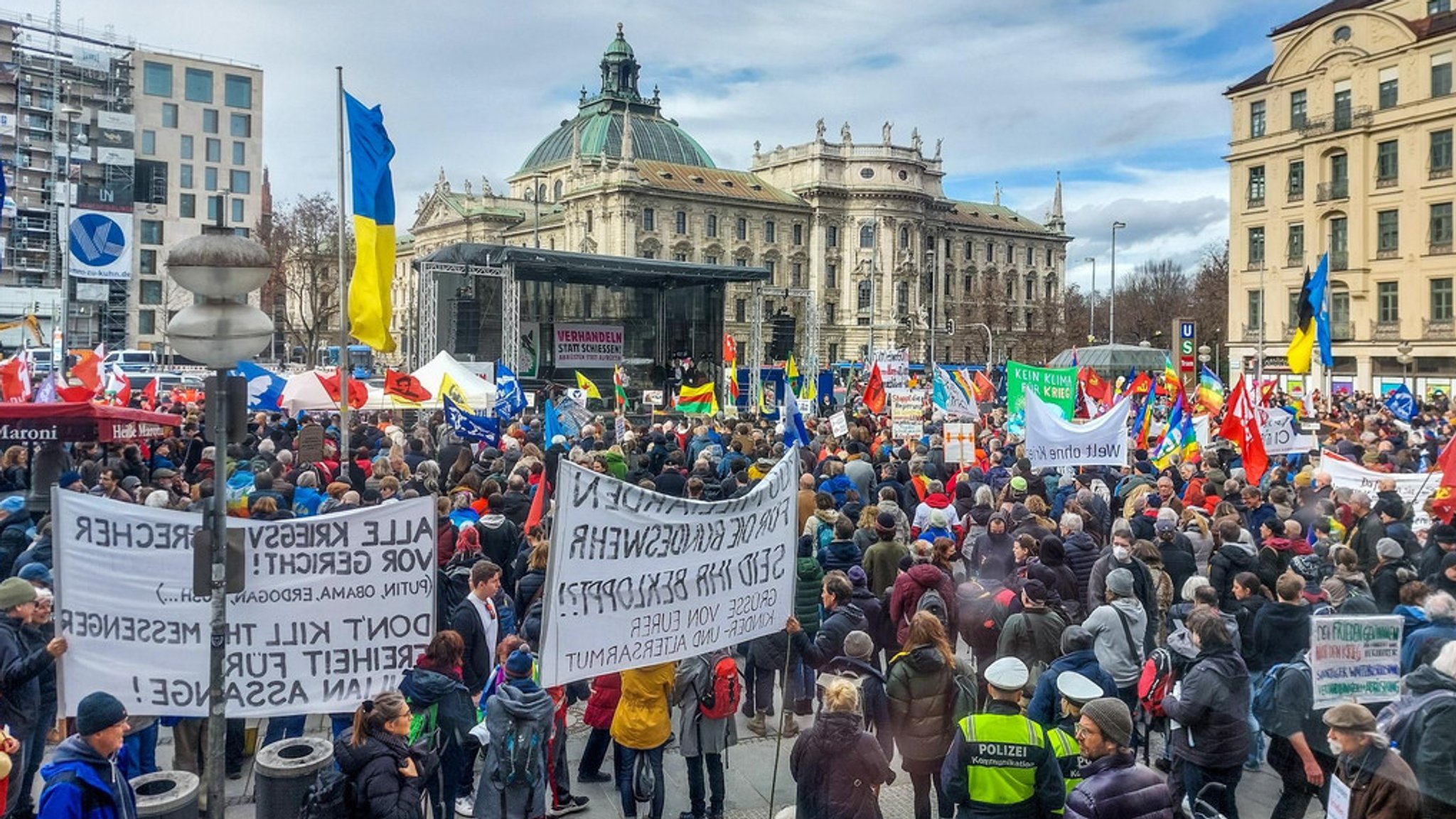 Zahlreiche Menschen, die mit Plakaten gekommen waren zur Auftaktkundgebung der "Anti-Siko-Demo" am Stachus in München.