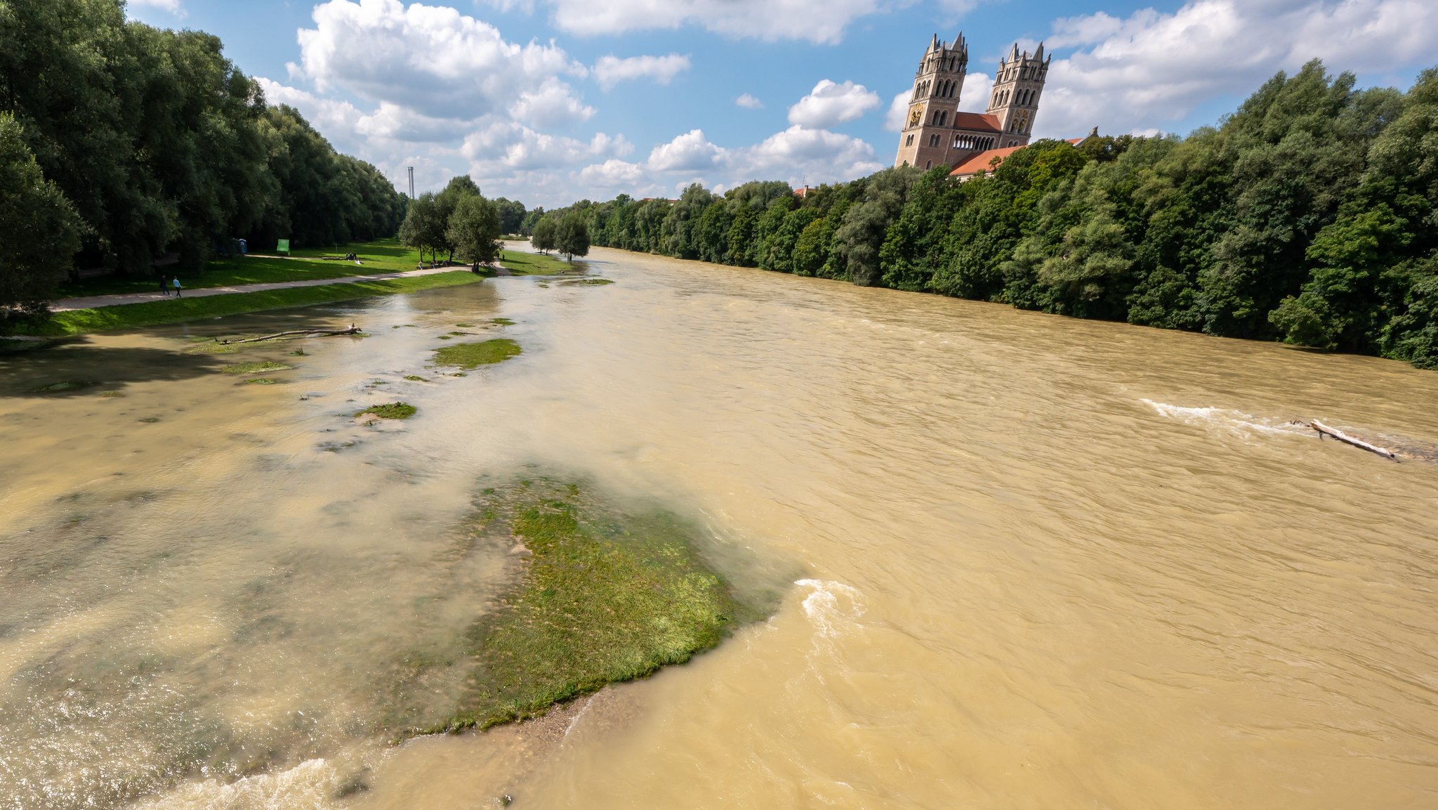 Braunes Hochwasser der Isar. Im Hintergrund ragen die beiden Türme der Sankt Maximilian Kirche in den Himmel (Archivbild)