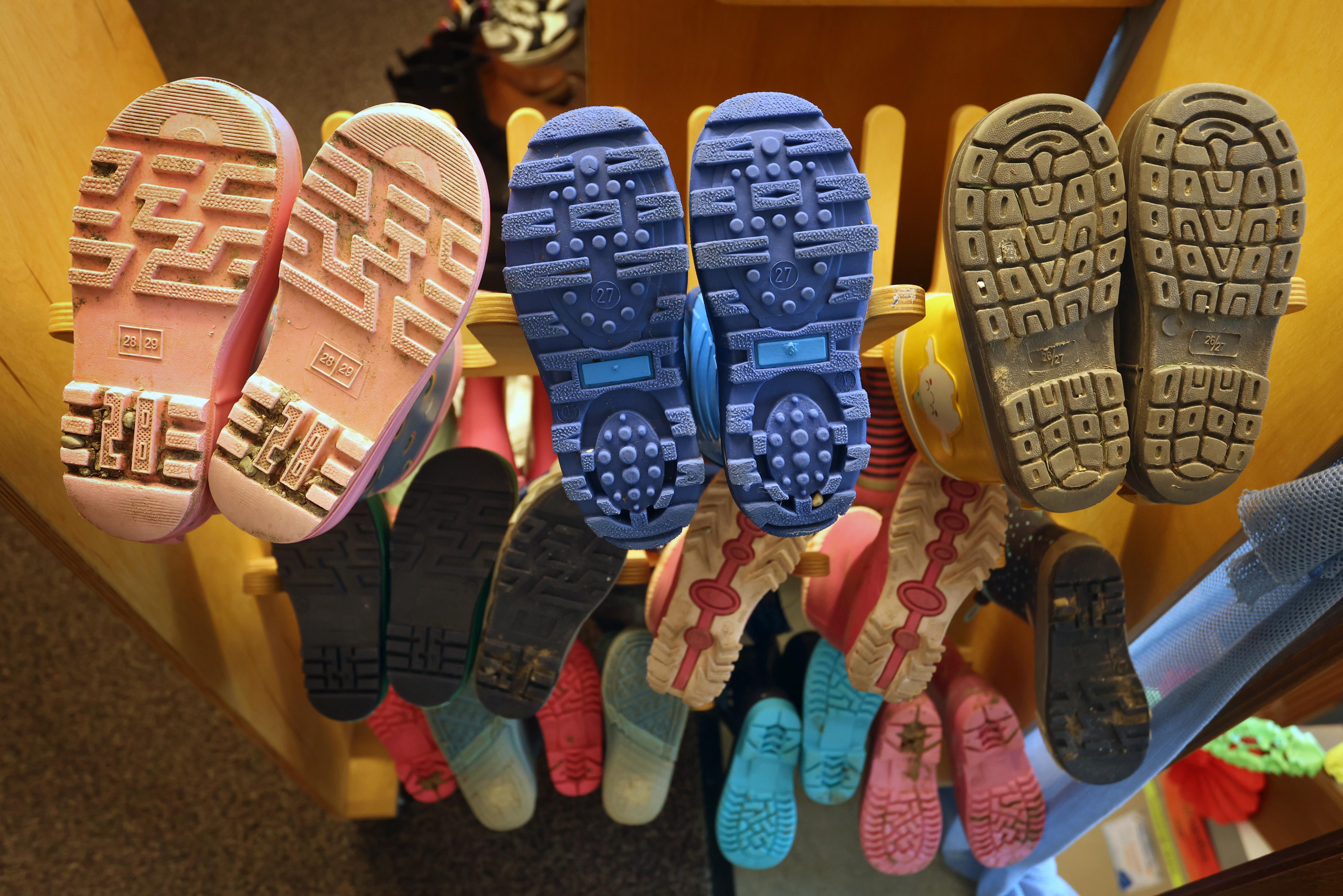 Symbolbild: kleine Gummistiefel hängen in einer Kita übereinander