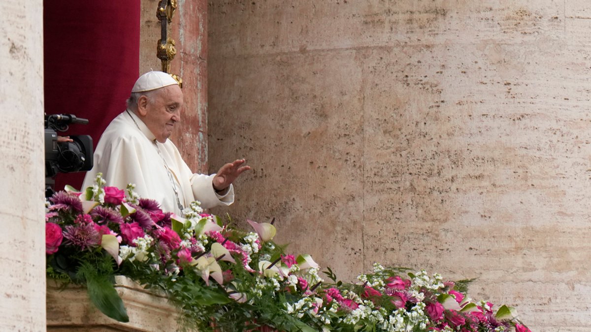 Papst Franziskus winkt den Gläubigen zu, bevor der den Segen "Urbi et Orbi" spendet - der Stadt Rom und dem Erdkreisfür 