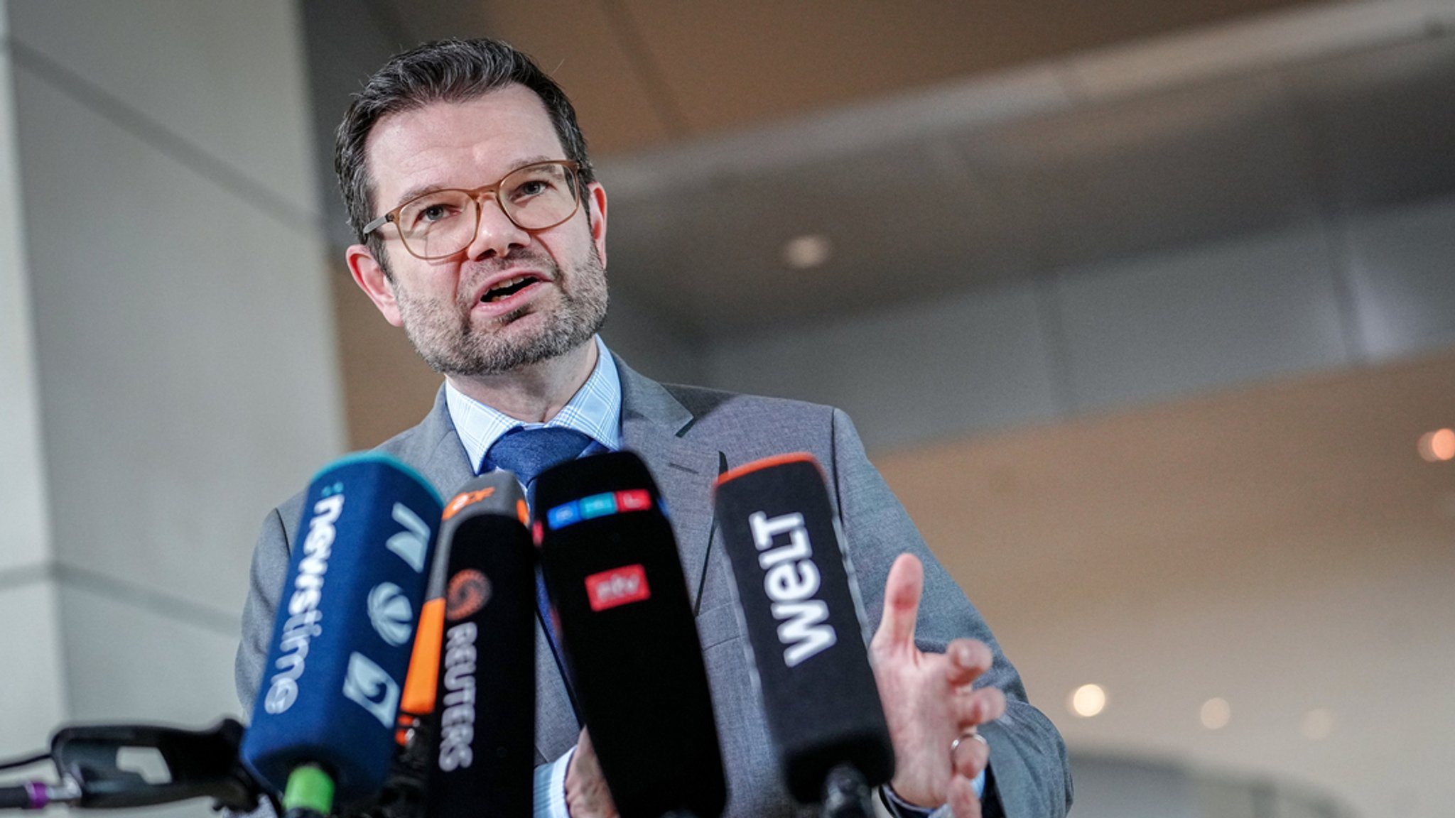 Justizminister Marco Buschmann spricht in mehrere Mikrophone