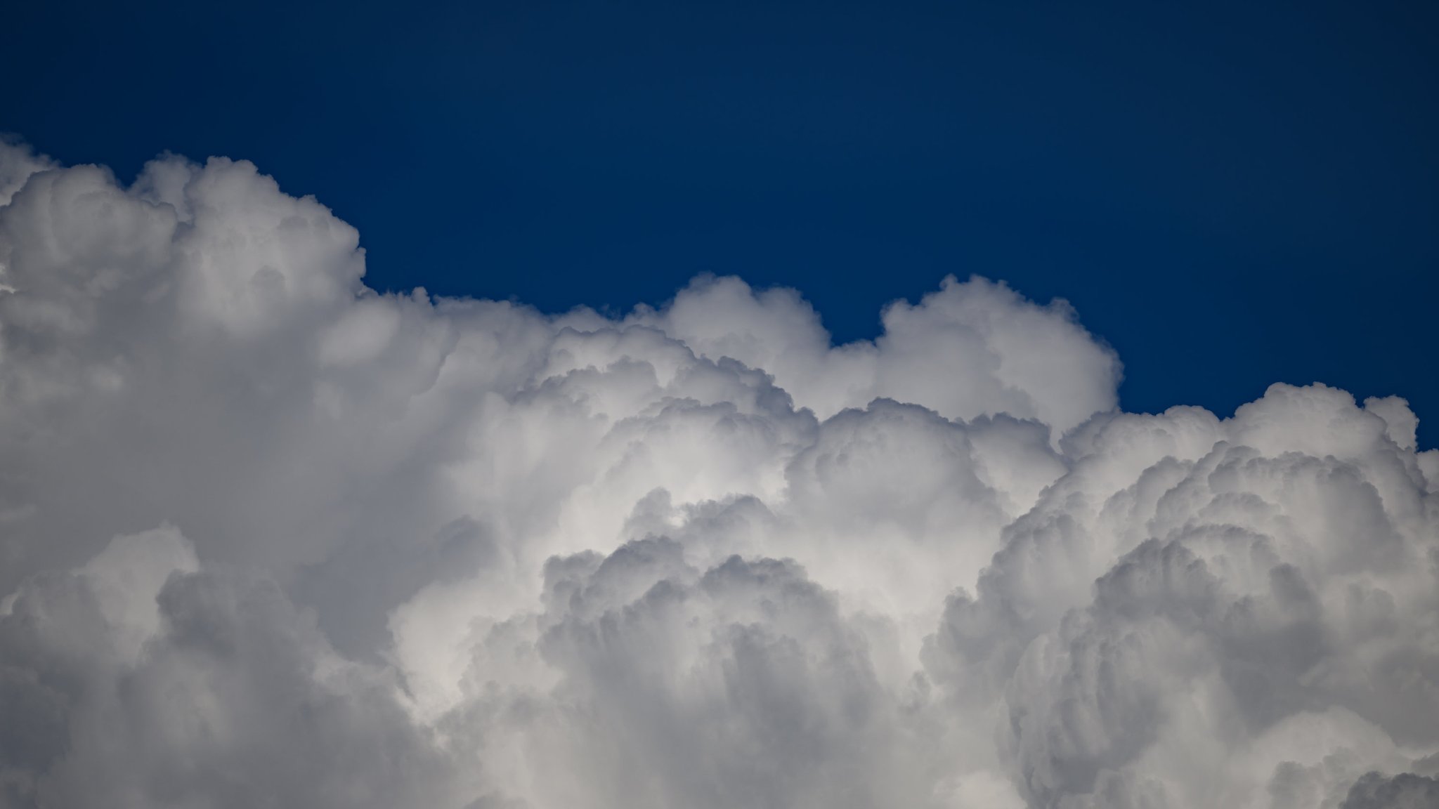 Regenwolken ballen sich vor blauem Himmel.