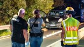Polizeibeamte und ein Mitarbeiter des THW stehen auf der Autobahn vor einem Transporter. Davor liegen Gegenstände auf der Fahrbahn.  | Bild:News 5 / Merzbach