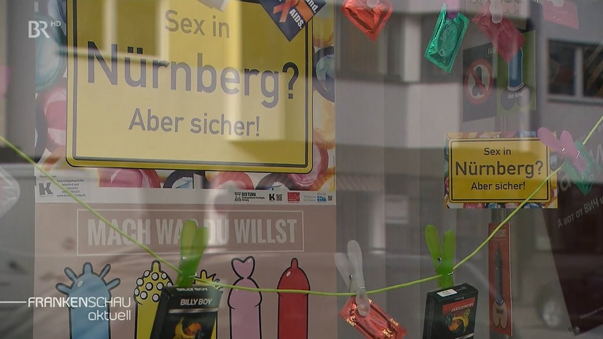 Blick durch ein Schaufenster, in dem ein Schild hängt "Sex in Nürnberg? Aber sicher!"