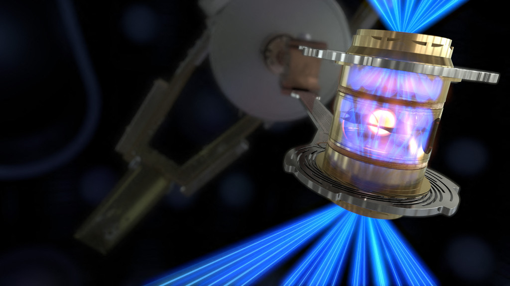 Das Bild zeigt eine künstlerische Darstellung eines Kernfusions-Experiments. Darauf sieht man eine Kammer, in die von oben und von unten bläuliche Laserstrahlen eingeschossen werden. Die Laserstrahlen erhitzen die Wände der Kammer. So werden Röntgenstrahlen erzeugt, die auf eine Kugel mit fusionsfähigem Material im Inneren der Kamera treffen. Im Inneren der Kugel werden so Fusionsprozesse gezündet und Energie freigesetzt. 