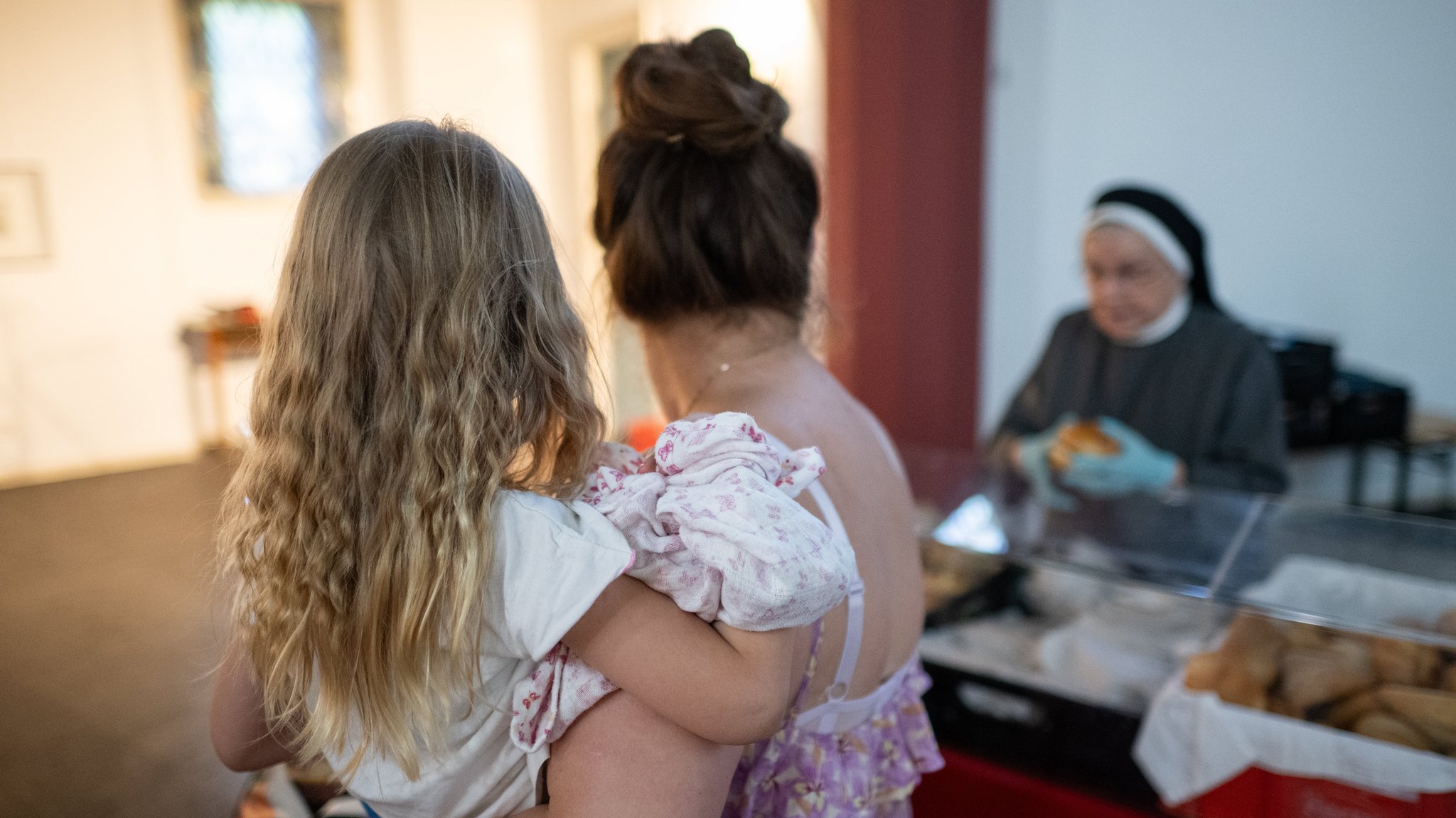 Mutter mit Kind an einer Ausgabestelle der Tafel