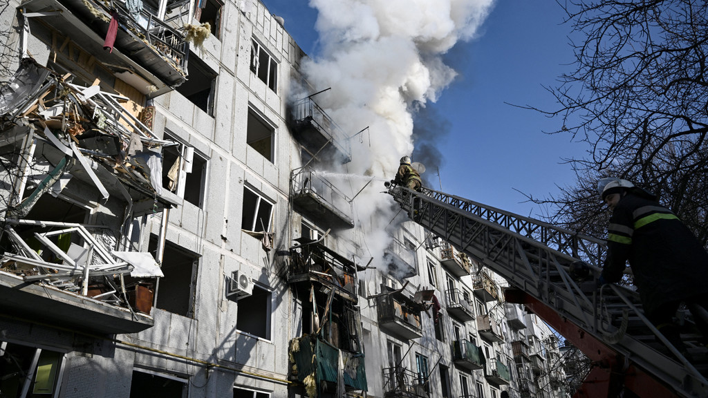 Feuerwehrmänner löschen den Brand in einem zerstörten Gebäude in der ukrainischen Stadt Tschuhujiw 