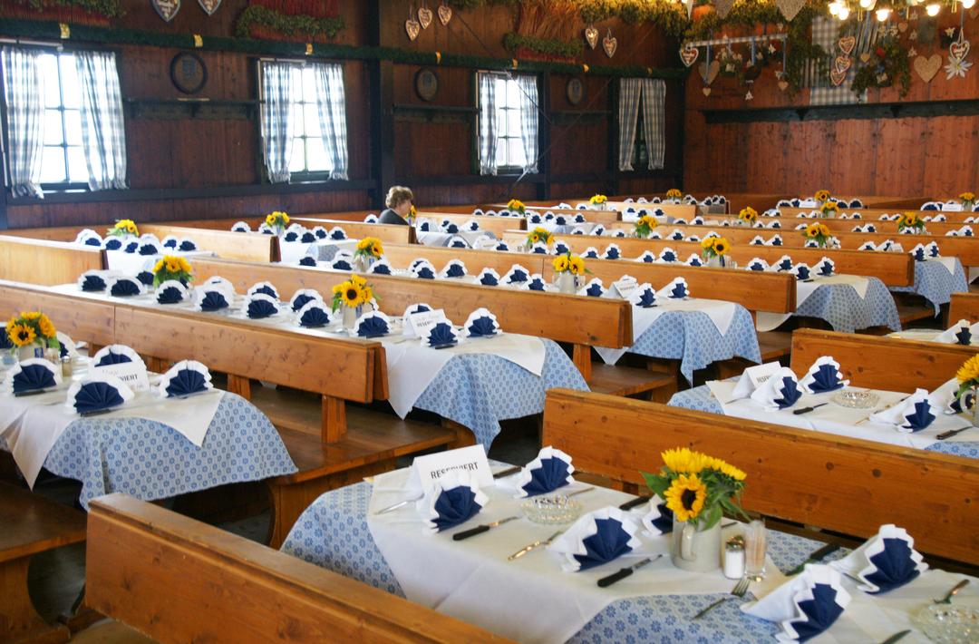 In einem Wiesnzelt sind viele dekorierte Tische zu sehen - die alle reserviert sind