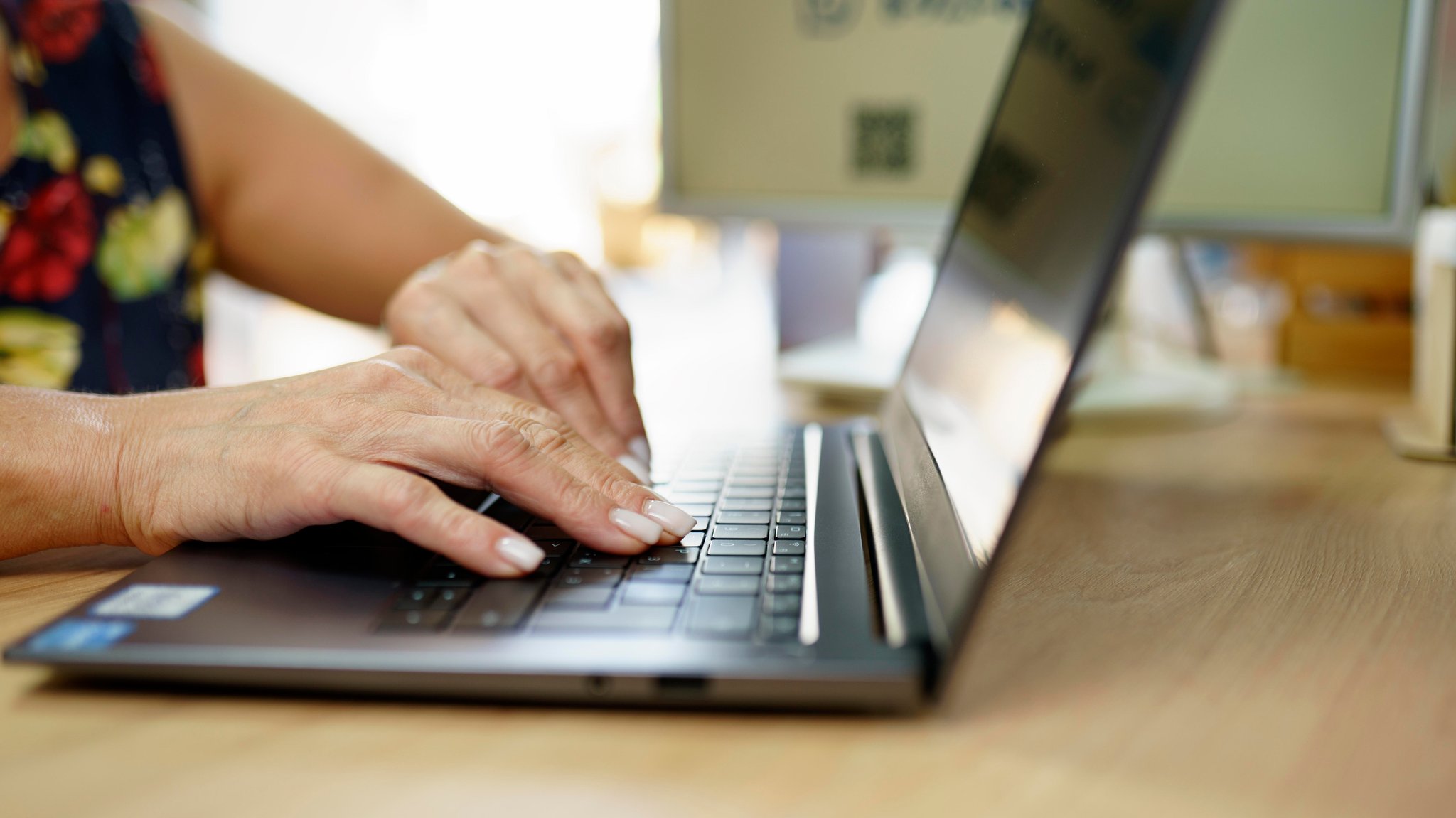 Frau sitzt am Laptop.