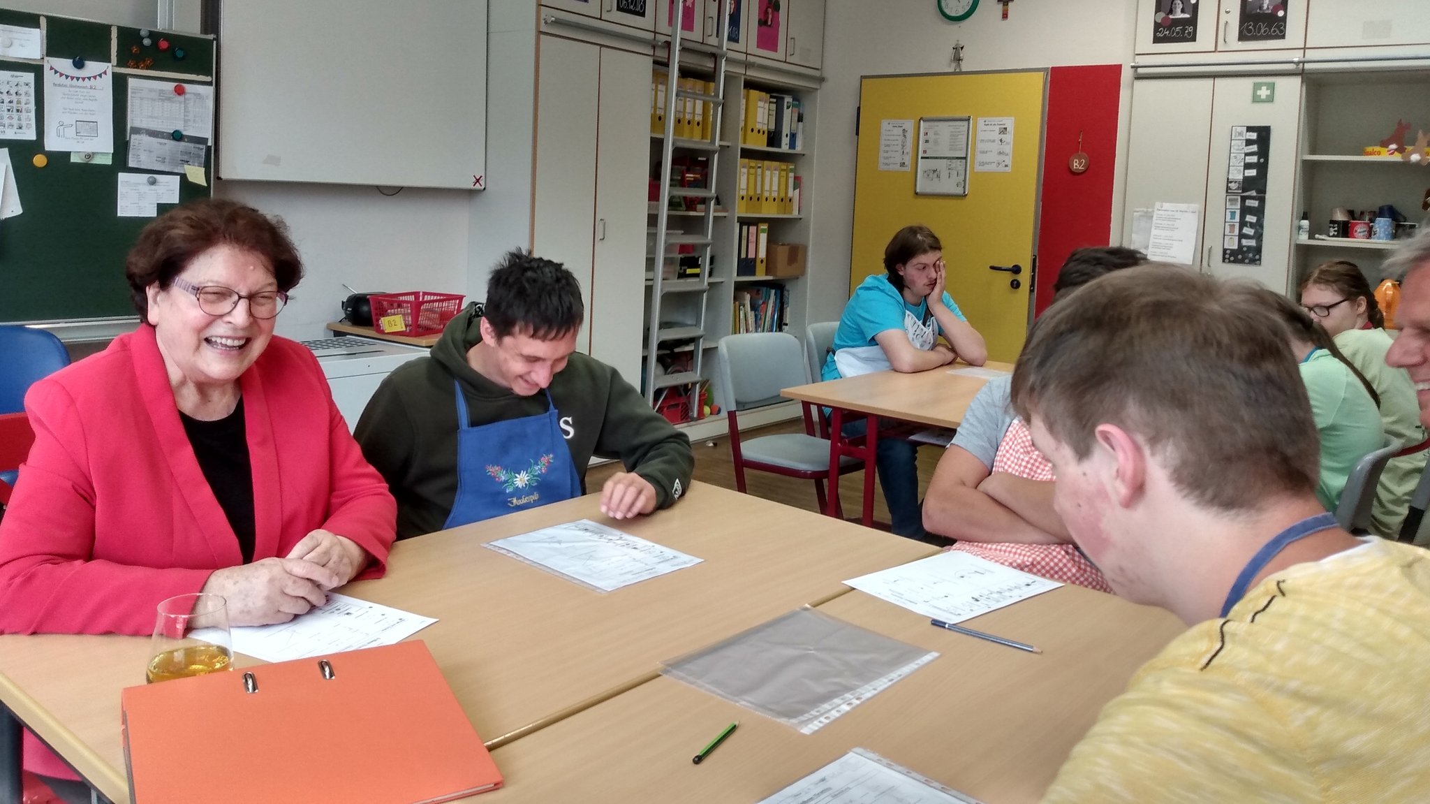 Die Vorsitzende des Lebenshilfe-Landesverbands, Barbara Stamm, sitzt in einem Klassenzimmern mit Schülern an einem Tisch.