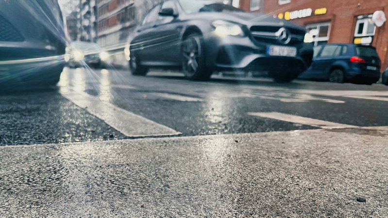 Eine Straße überzogen mit Blitzeis. Im Hintergrund Autos | Bild: picture alliance/dpa | Paul Zinken Eine Straße überzogen mit Blitzeis. Im Hintergrund Autos