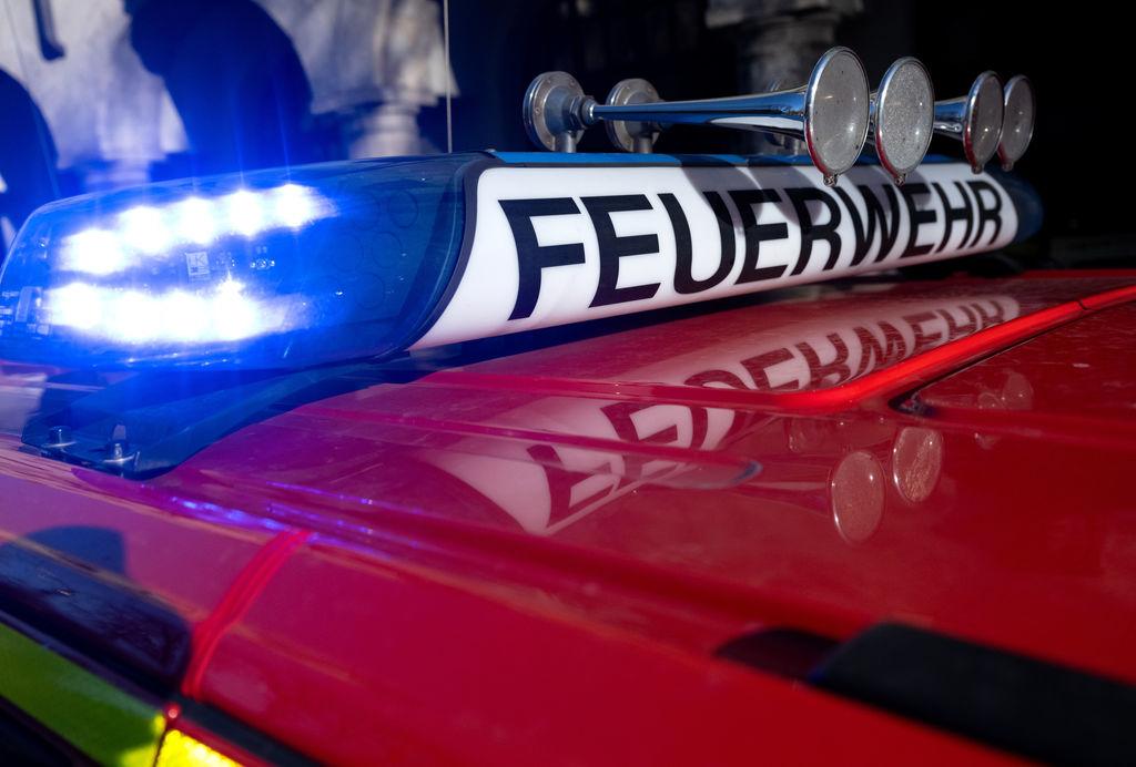 Ein Einsatzfahrzeug der Feuerwehr mit eingeschaltetem Blaulicht.
