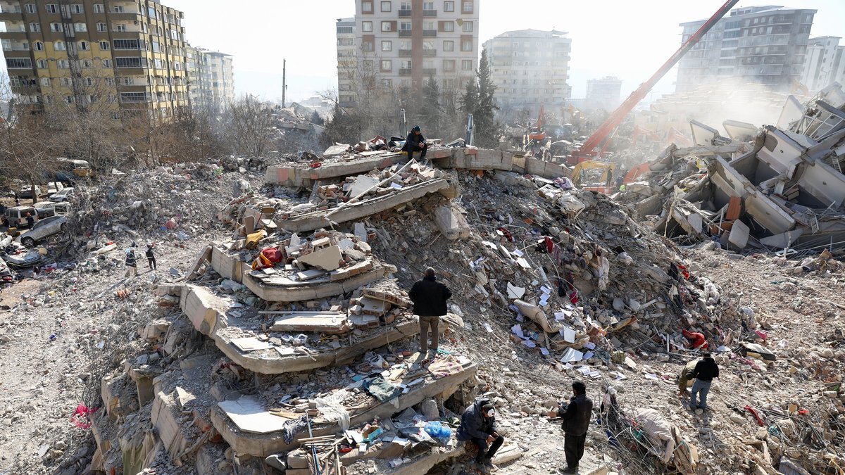 Menschen auf Trümmern im türkischen Erdbebengebiet