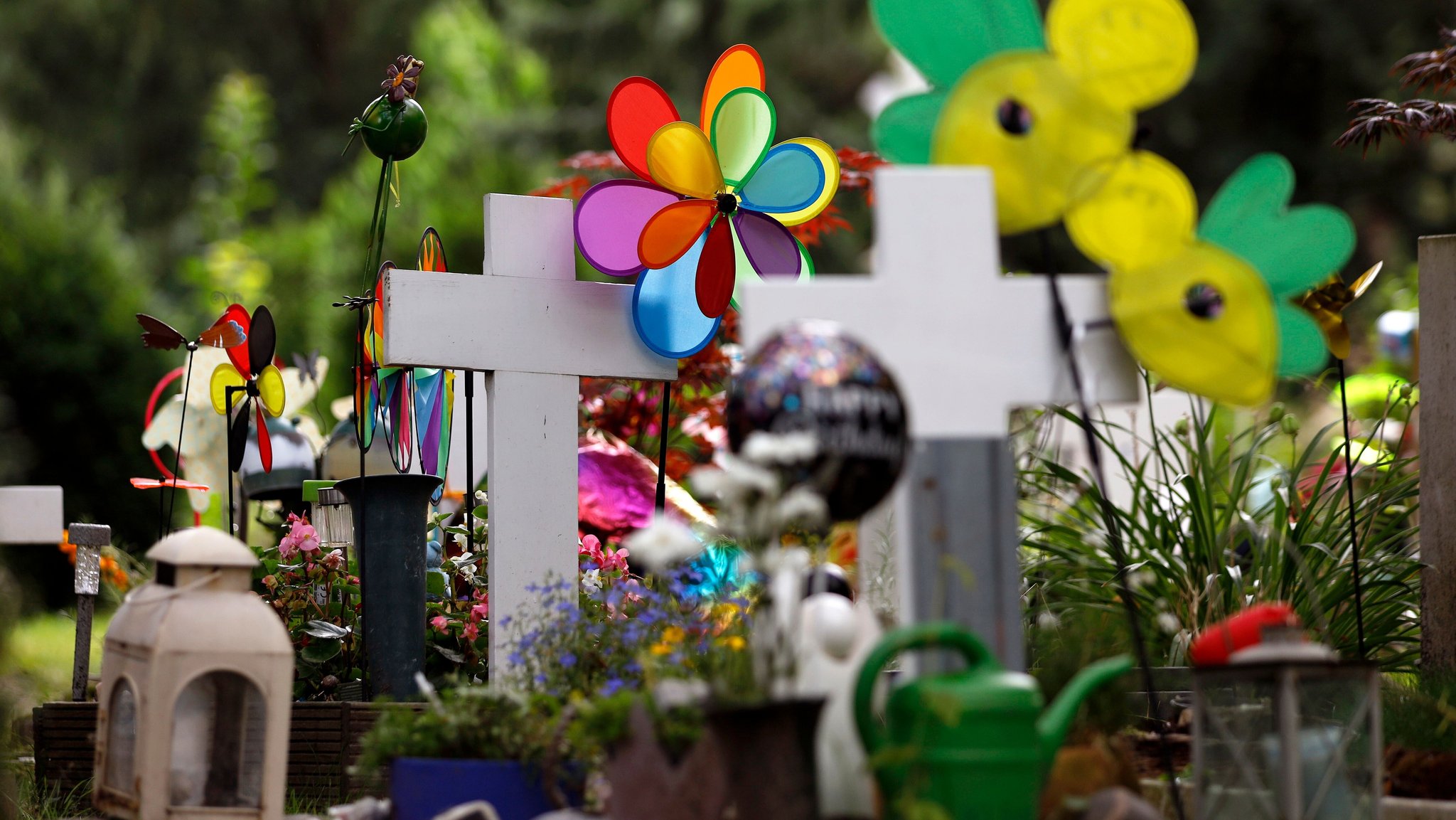Friedhof mit Kreuzen, Kerzen und Kinderspielzeug. | Bild: picture alliance / Geisler-Fotopress | Christoph Hardt/Geisler-Fotopres Friedhof mit Kreuzen, Kerzen und Kinderspielzeug.