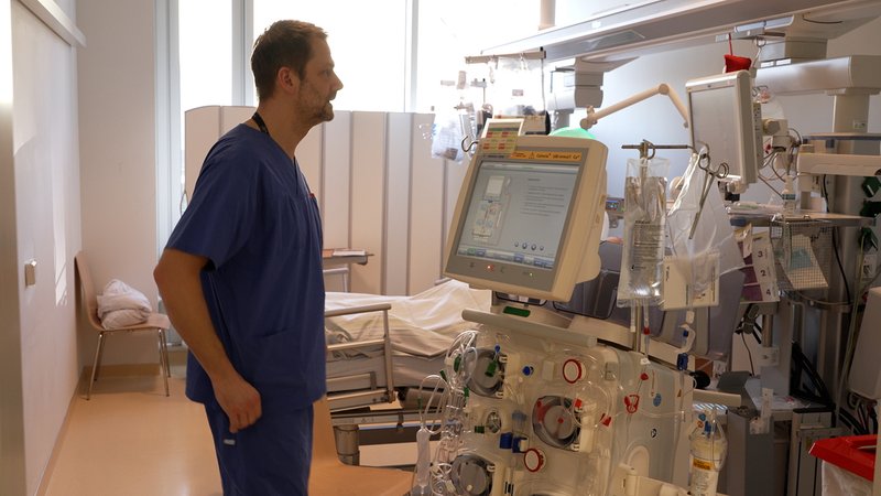 Ein Pfleger steht in einem Patientenzimmer. | Bild: BR Ein Pfleger steht in einem Patientenzimmer.