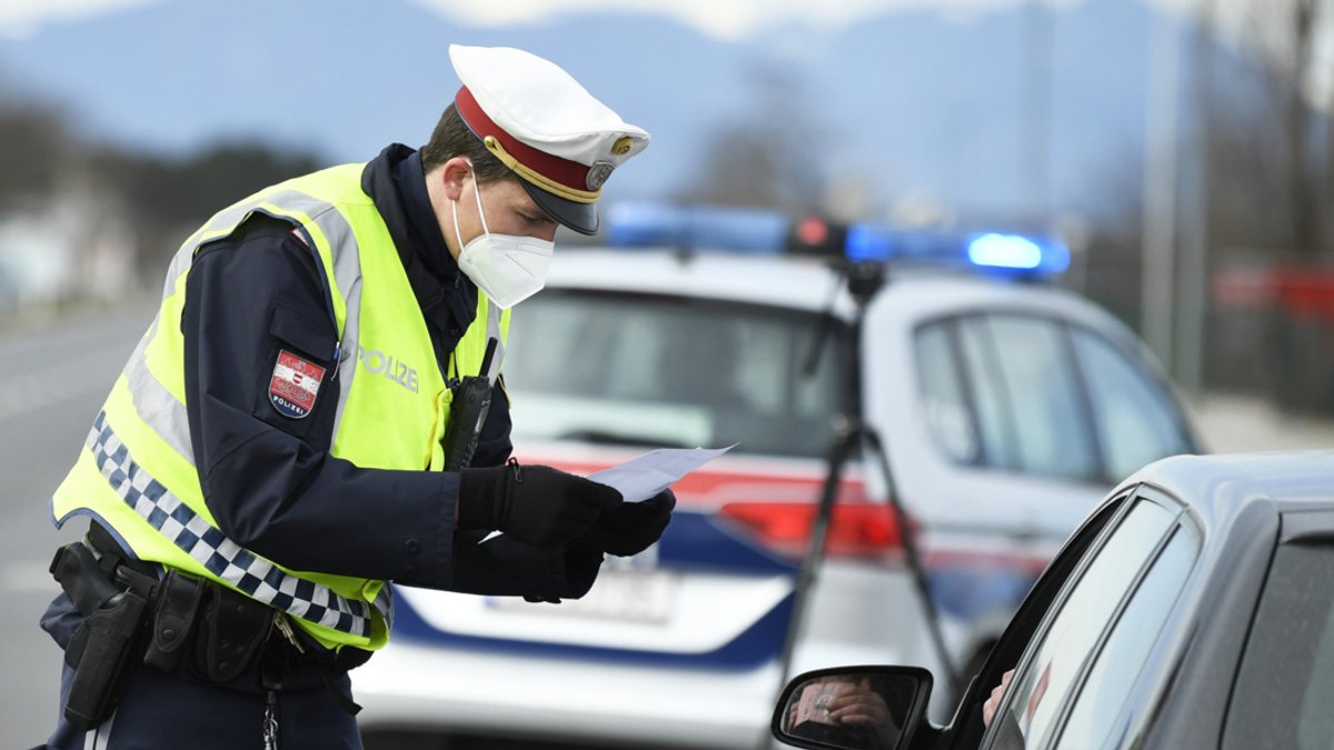 Ein österreichischer Polizist kontrolliert einen Impfnachweis