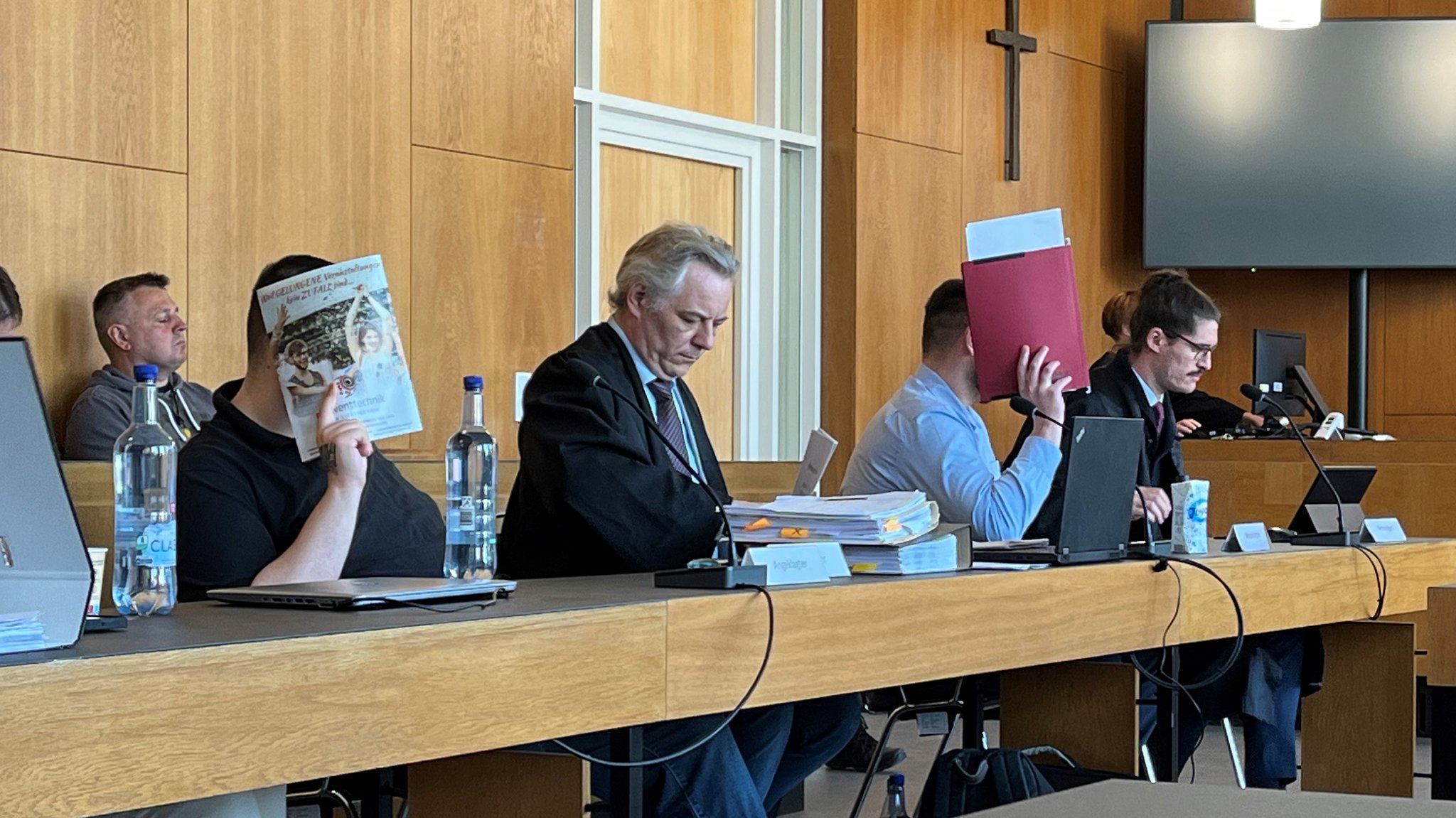 Auf der Anklagebank vor dem Landgericht Aschaffenburg: Die beiden jungen Männer, die einen Obdachlosen halbtot geschlagen haben, verdecken ihre Gesichter. 