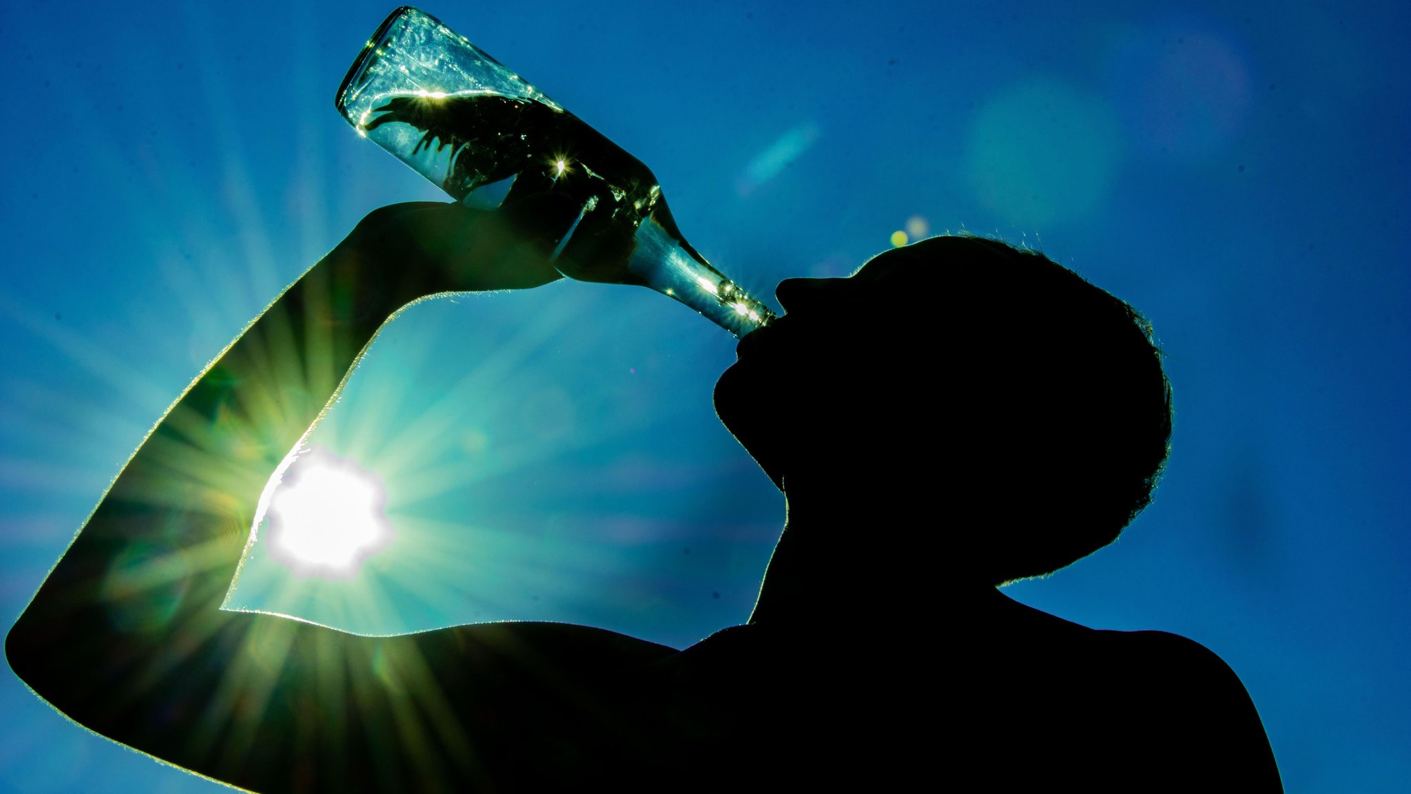 Mann trinkt Wasser aus einer Flasche