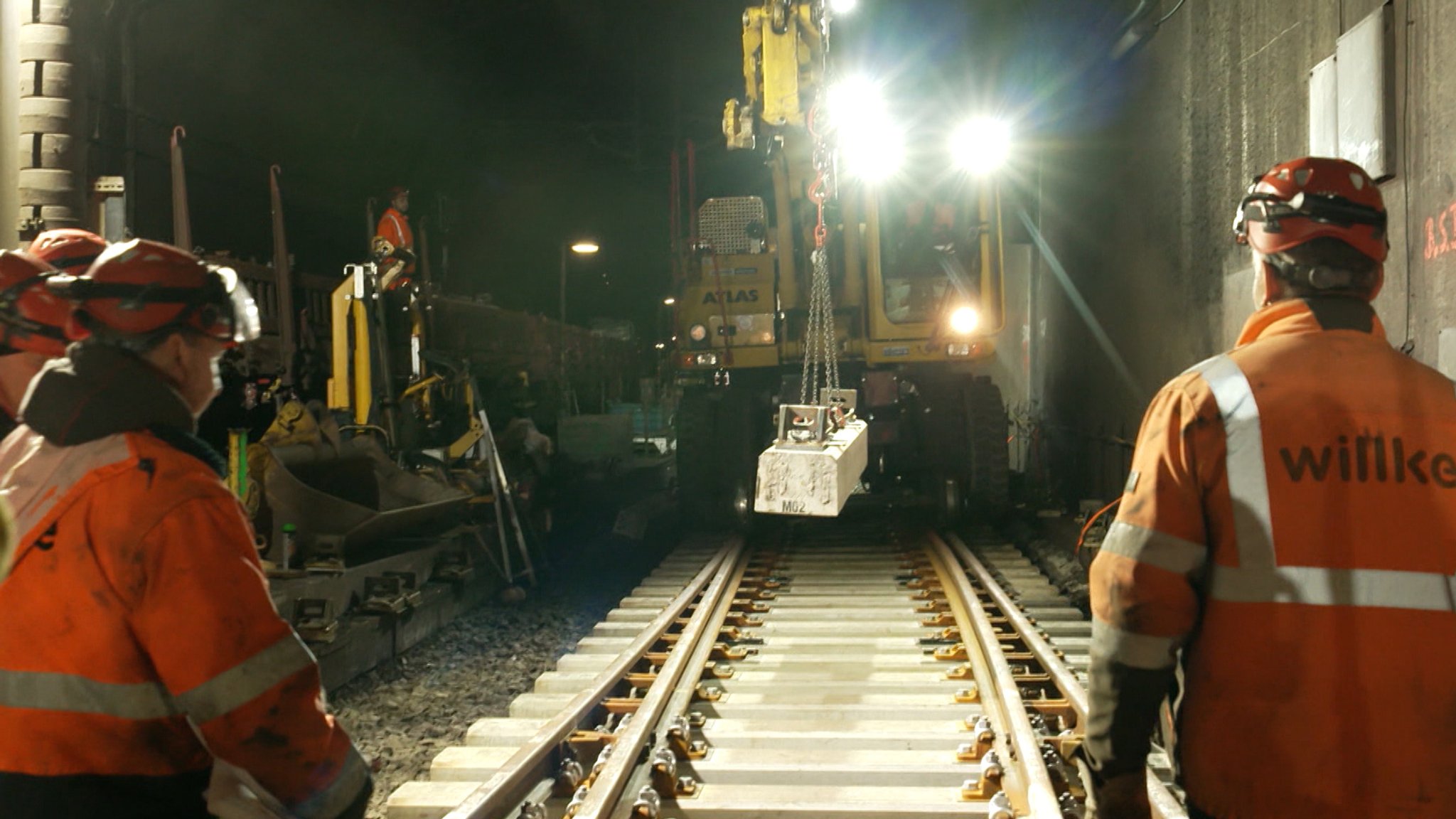 Ein Zweiwegebagger bringt eine neue Betonsschwelle zum Einbau einer Weiche im Bahnhof Isartor.