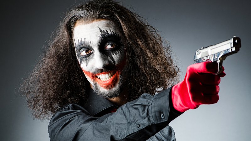 Geschminkter Mann mit langen Haaren hält eine Pistole in der Hand. | Bild: colourbox.com Geschminkter Mann mit langen Haaren hält eine Pistole in der Hand.