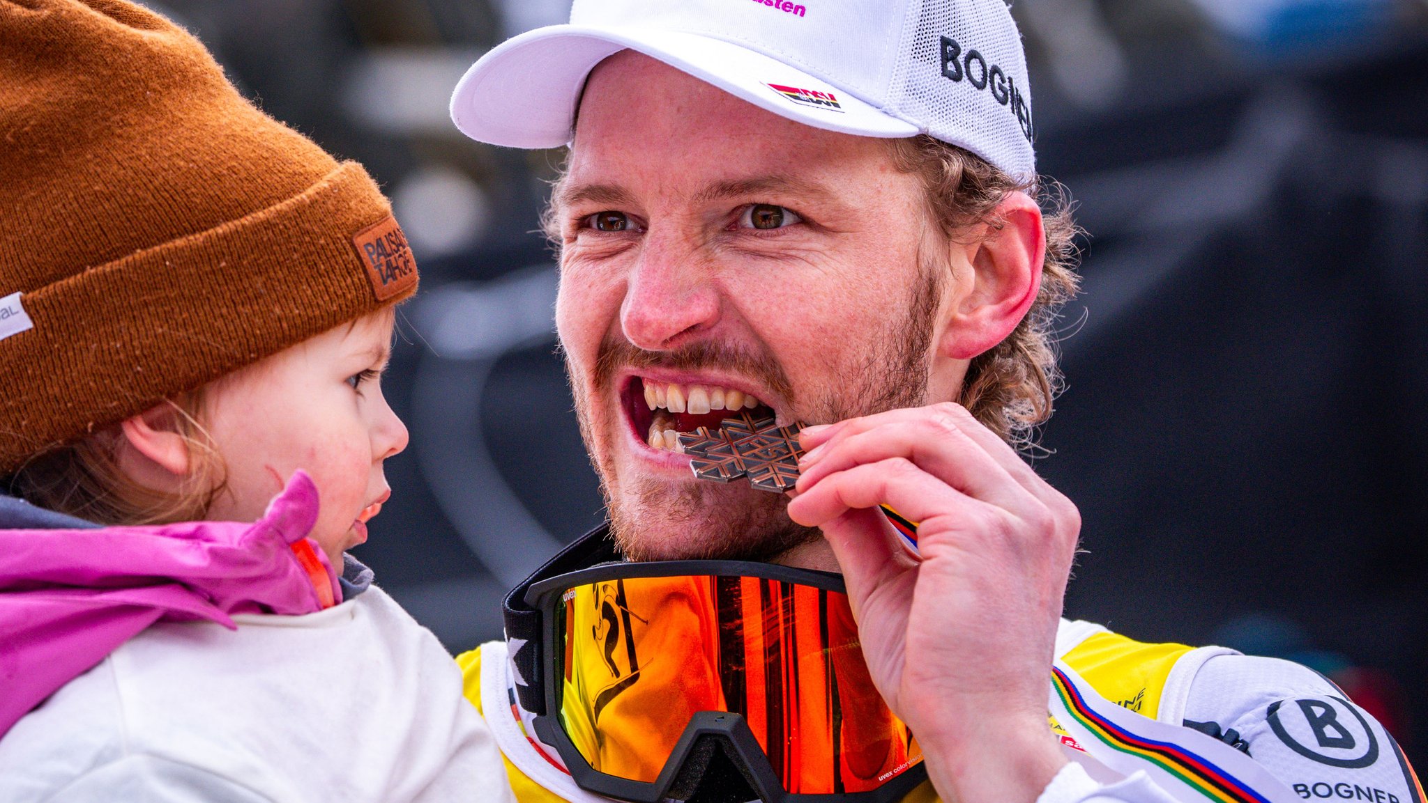 16.02.2025, Österreich, Saalbach-Hinterglemm: Ski alpin: Weltmeisterschaft, Slalom, Herren, 2. Durchgang, Linus Straßer aus Deutschland jubelt nach dem Gewinn der Bronzemedaille mit seinem Kind. 