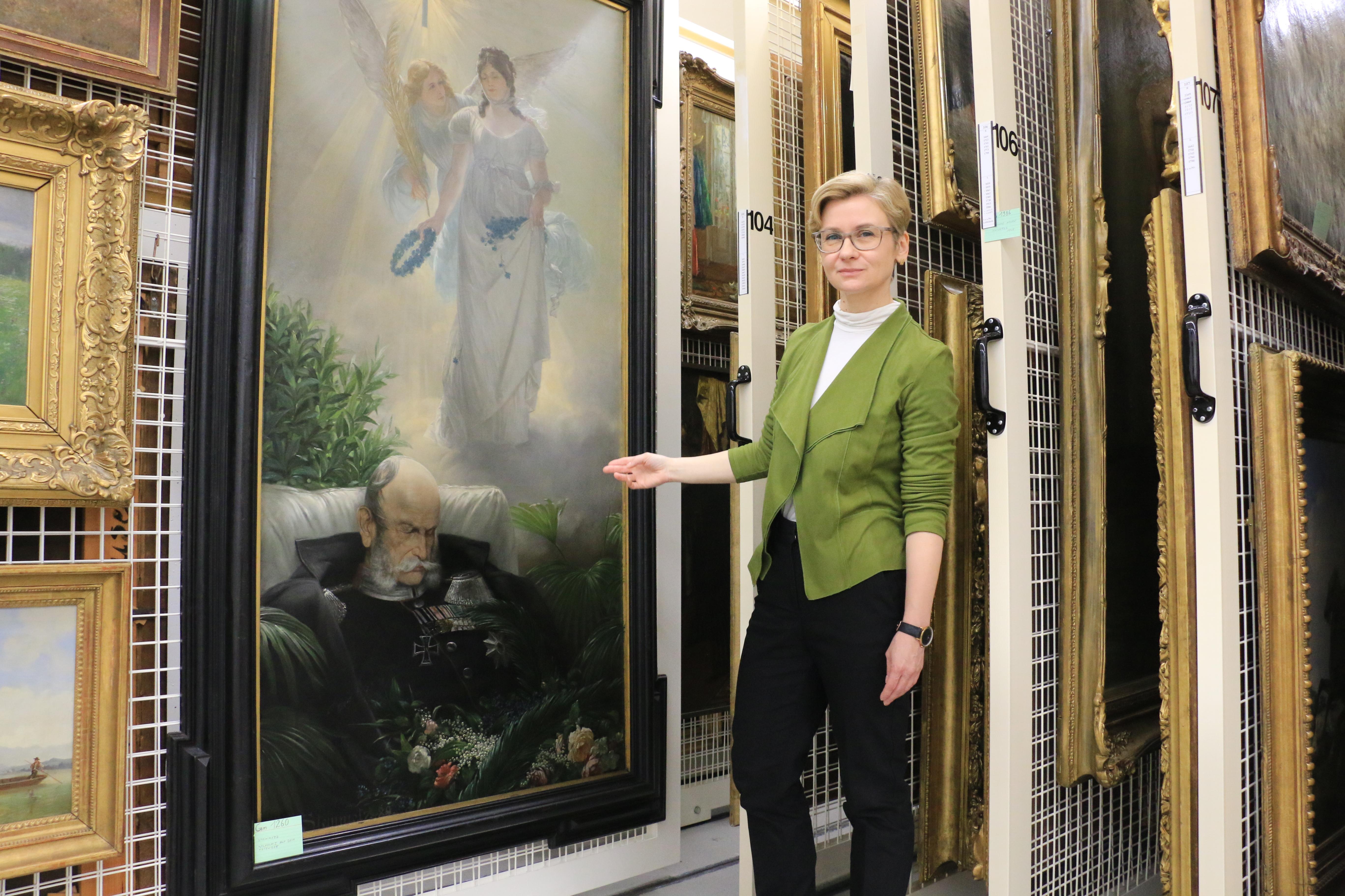 Die Expertin zeigt auf das Bild im Depot des Germanischen Nationalmuseums