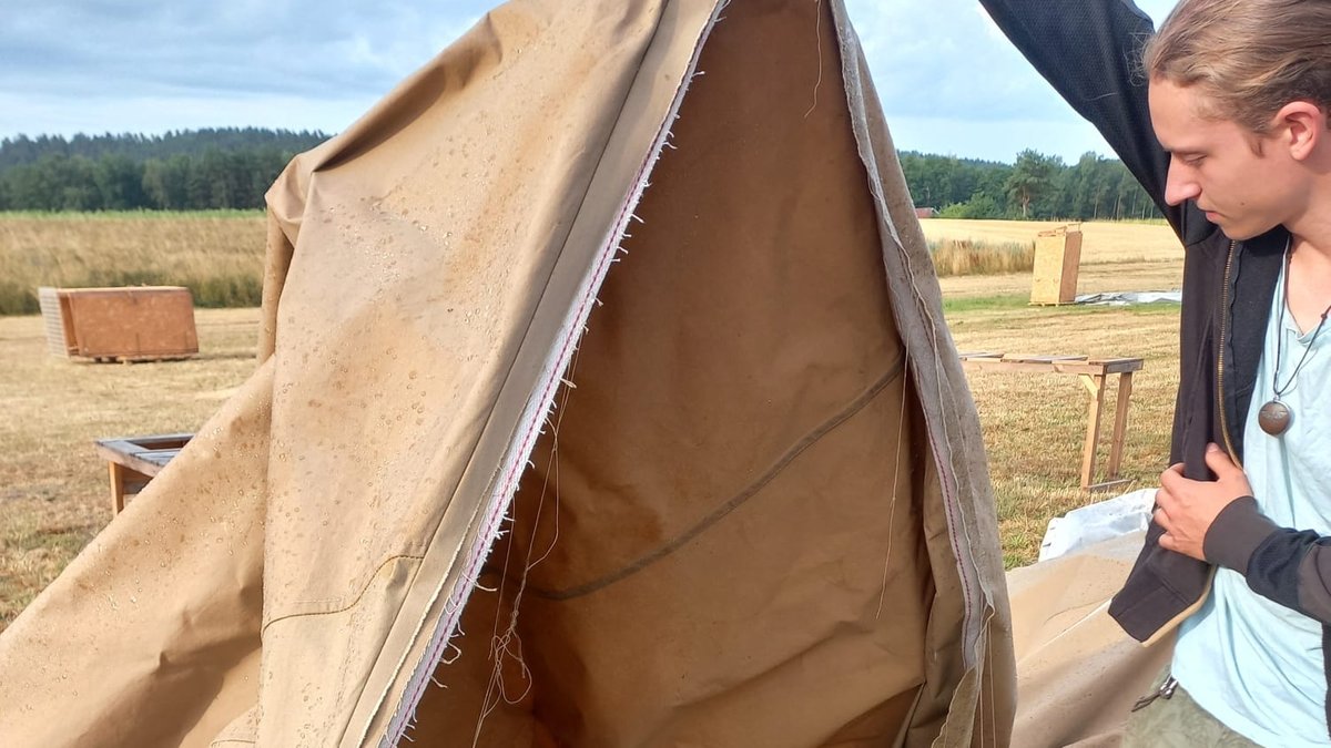 Ein Helfer mit einem niedergerissenen Zelt