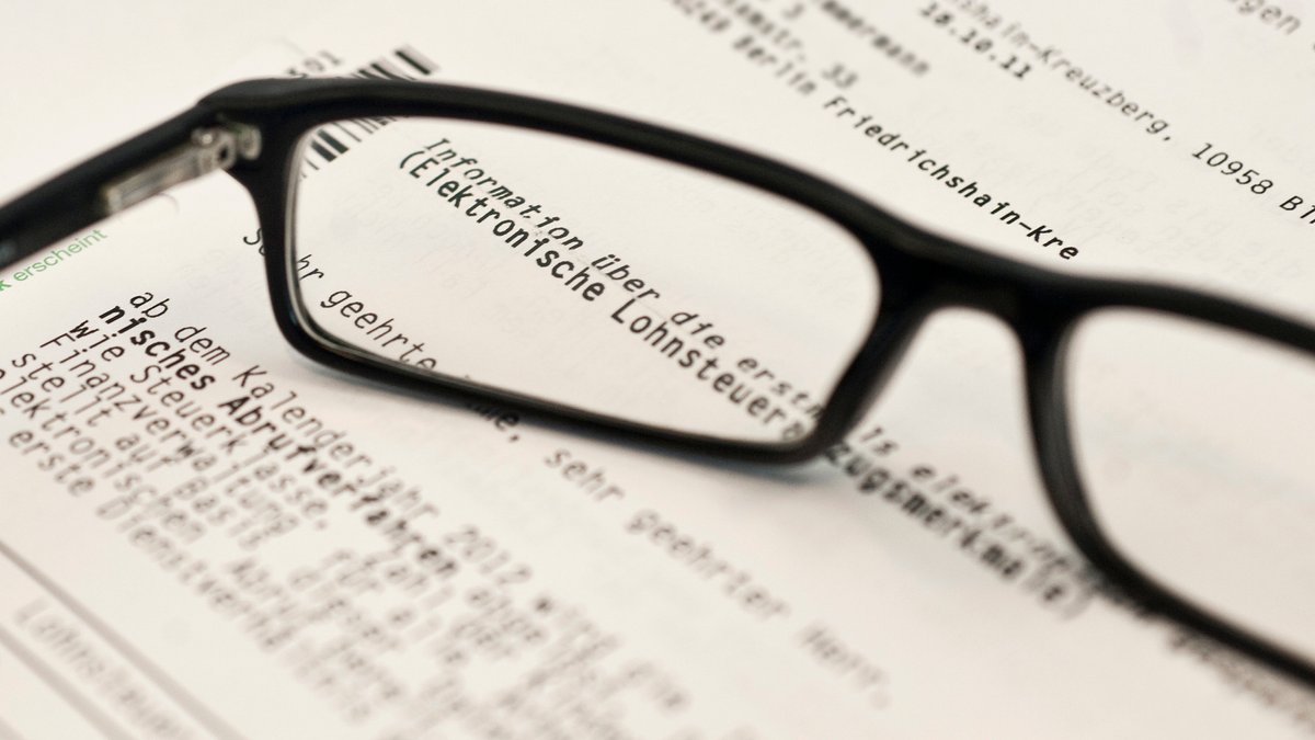 Symbolbild: Brille liegt auf einem Brief eines Finanzamtes