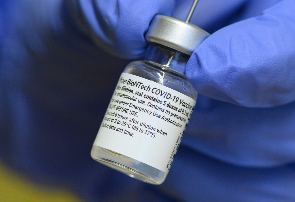 Eine Mitarbeiterin im Städtischen Klinikum Dresden, hält im Impfzentrum für Mitarbeiter ein Injektionsfläschchen mit dem Impfstoff von Biontech/Pfizer gegen Corona in den Händen.