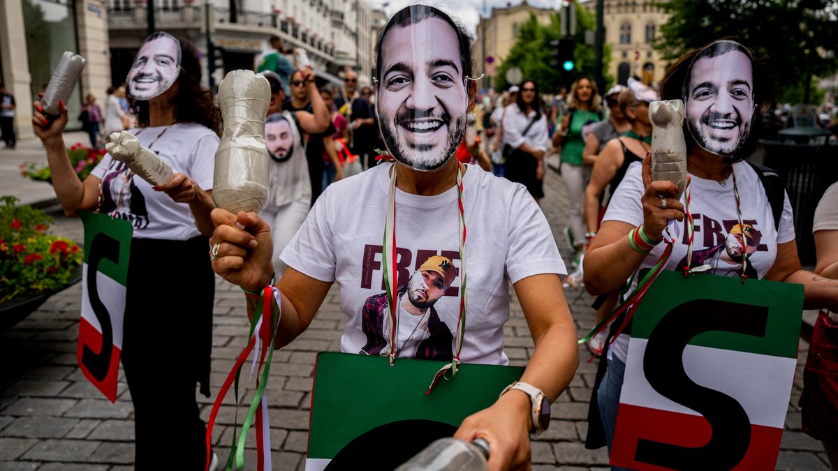 ARCHIVBILD: Eine Gruppe Exil-Iraner protestieren für Toomaj Salehi in Oslo am 08.07.2023. Sie tragen Masken mit Salehis Konterfei über ihren Gesichtern.