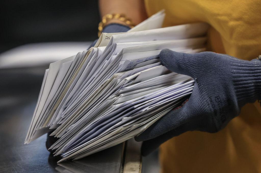 Eine Frau hält einen Stapel Briefe in der Hand