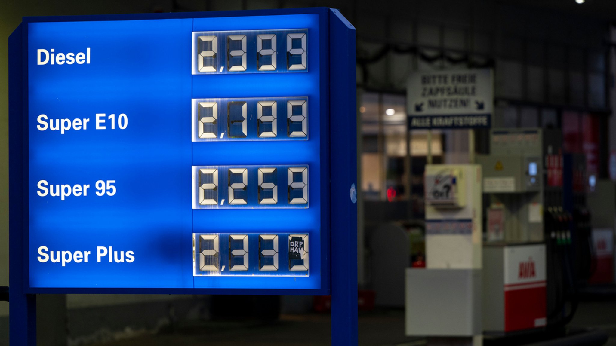 Die Preistafel einer Tankstelle in München vor einer Zapfsäule