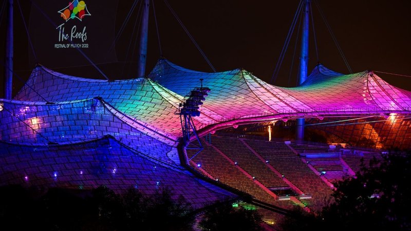 Das farbig angestrahlte Olympiastadion in München zum Start des Festivals "The Roofs", das die European Championships begleitet. 
