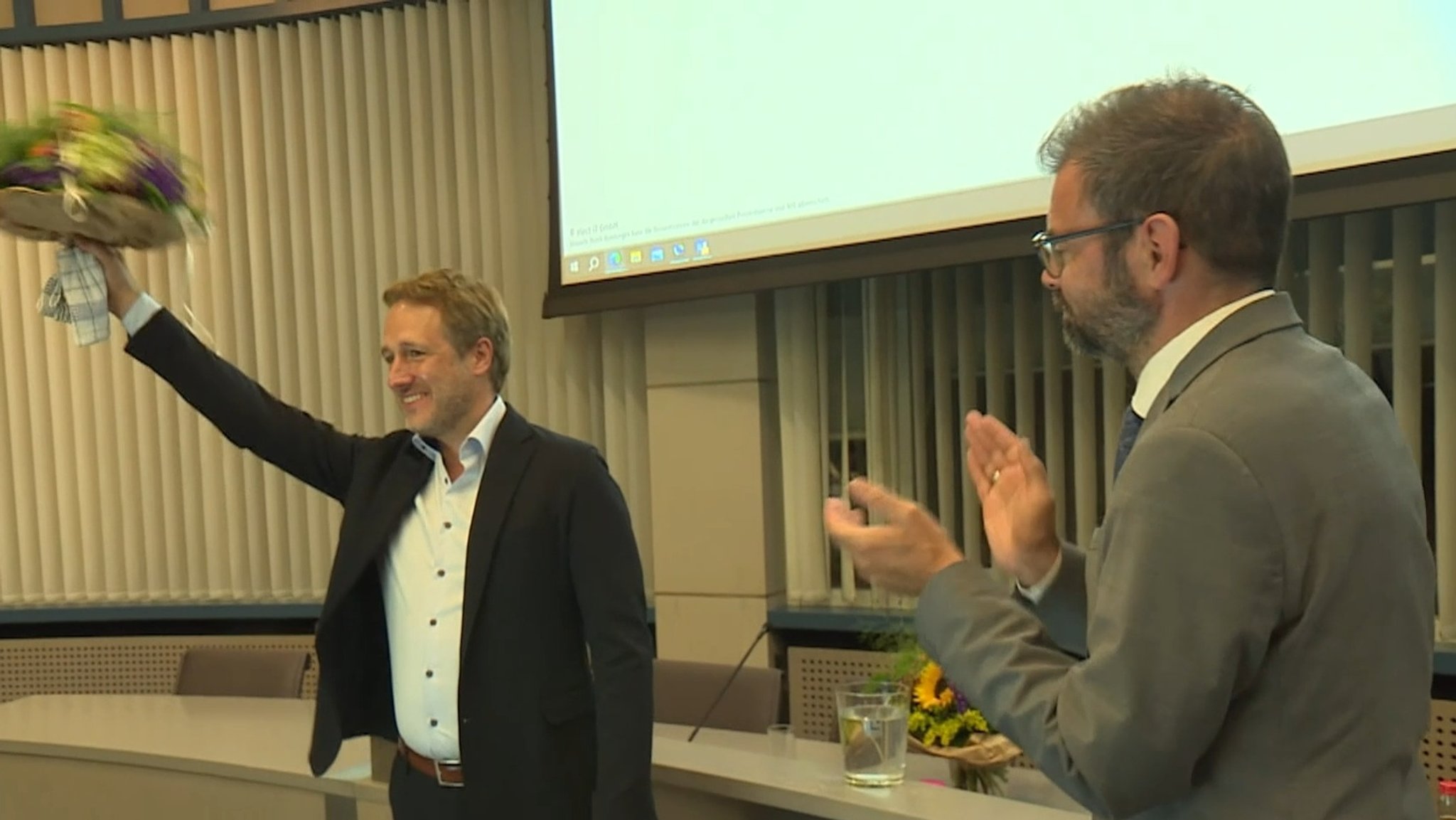 Martin Stock von der CSU (li.) mit Blumenstrauß in der Hand.