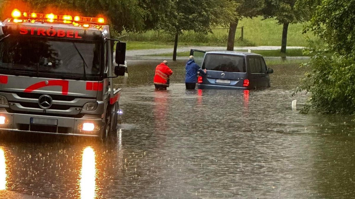 Ein Auto auf einer überfluteten Straße in Lindau am Bodensee zwischen Rehlings und Oberreitnau 