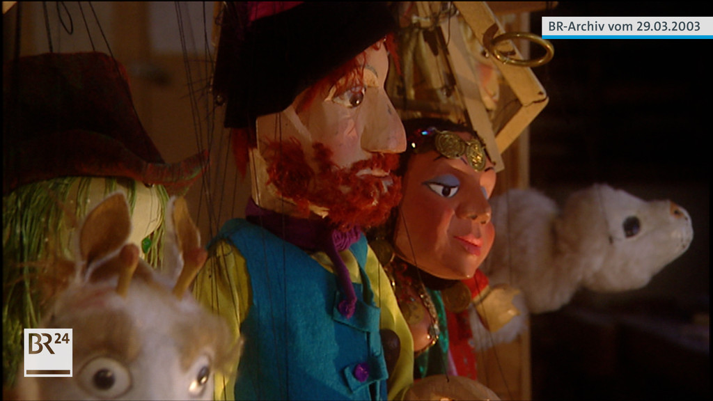 Marionetten der Augsburger Puppe im Profil an Fäden hängend
