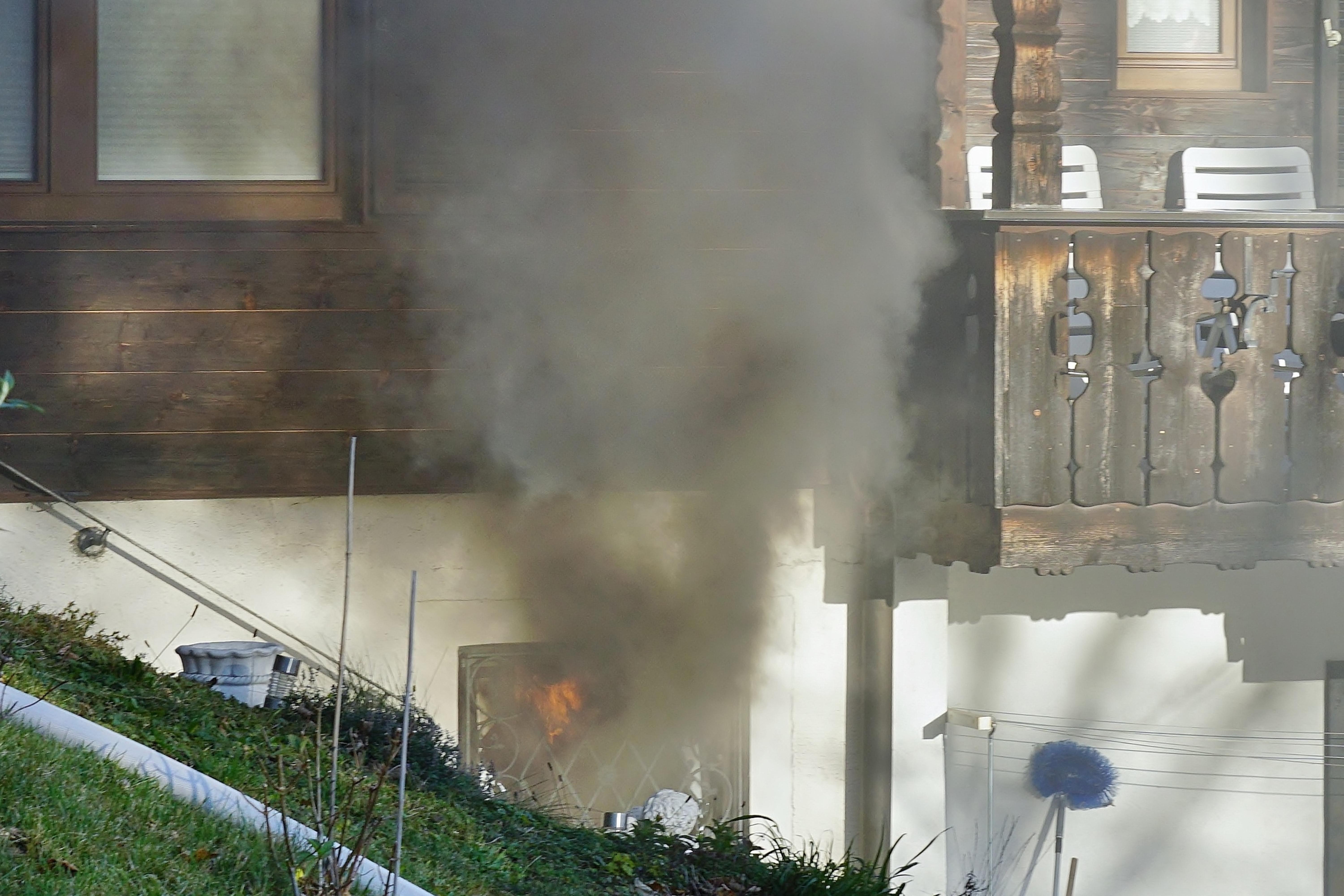 Aus einem Kellerfenster steigt schwarzer Rauch - im Inneren sieht man Feuer.
