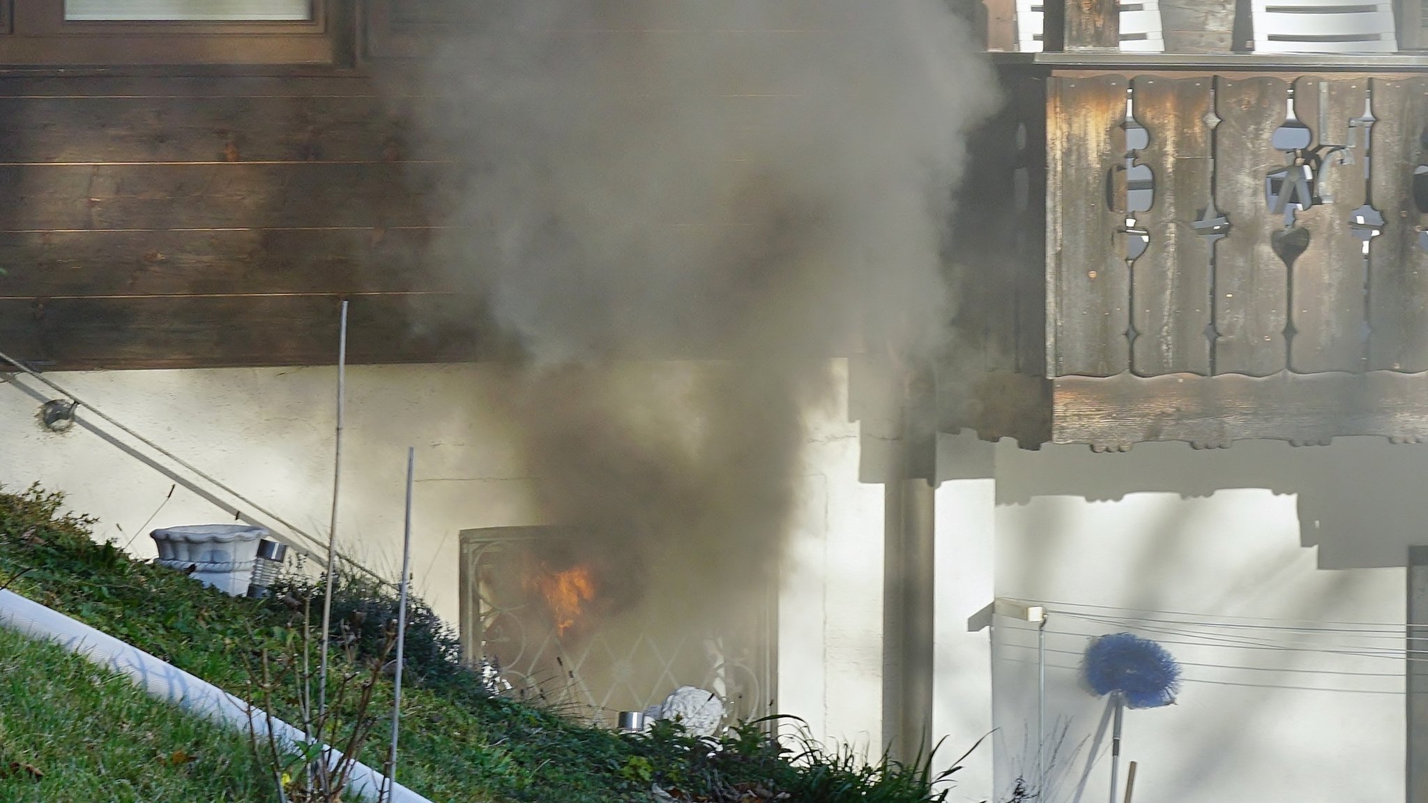 Aus einem Kellerfenster steigt schwarzer Rauch - im Inneren sieht man Feuer.