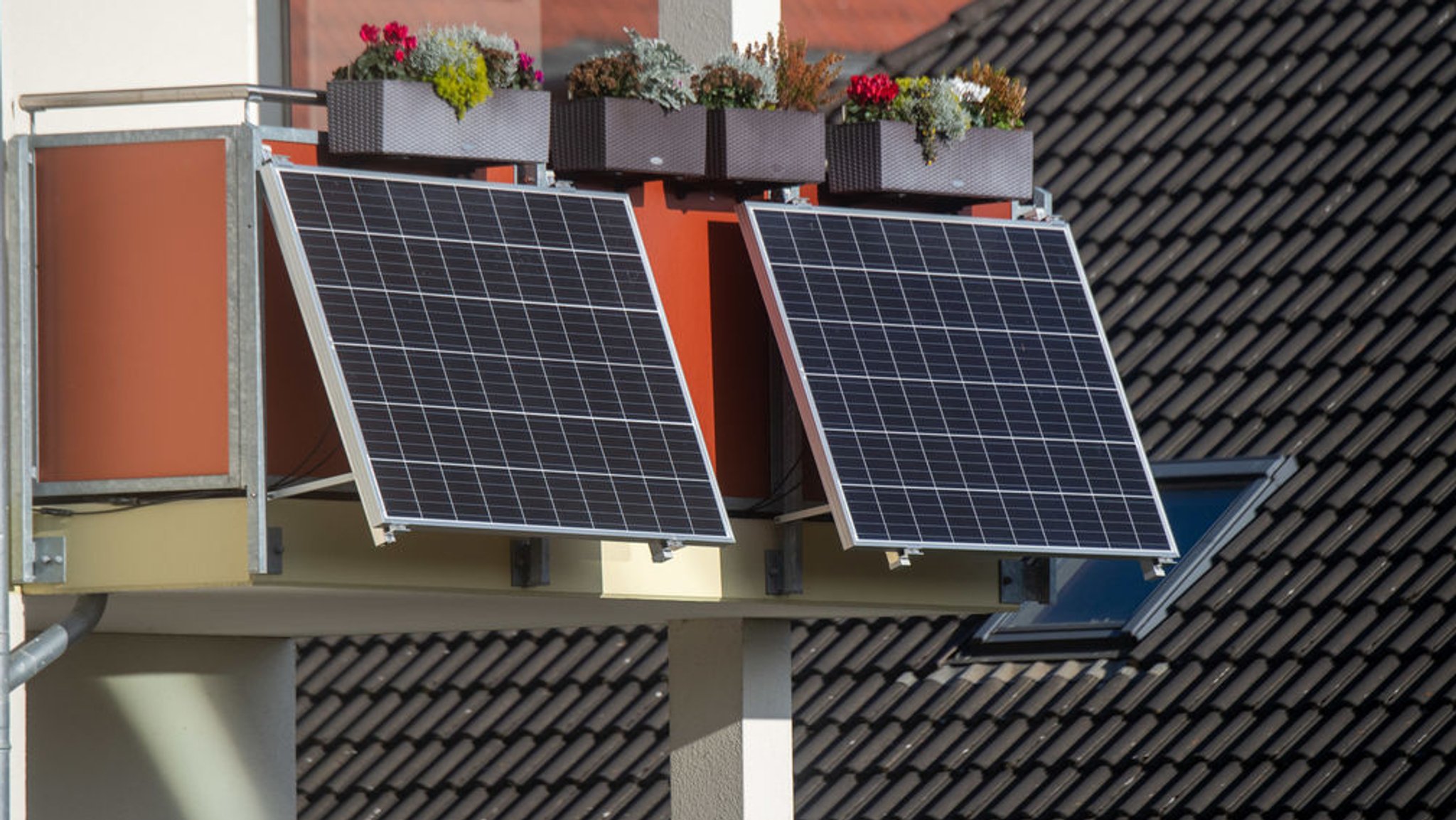 Solarmodule für ein sogenanntes Balkonkraftwerk hängen an einem Balkon.