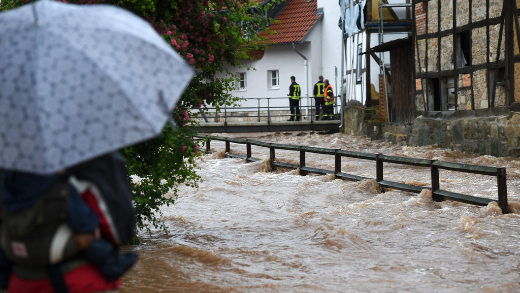 Feuerwehrleute beobachten die über die Ufer getretene Losse. Schwere Regenfälle hatten seinerzeit zahlreiche Bäche in Nordhessen zum Überlaufen gebracht. 