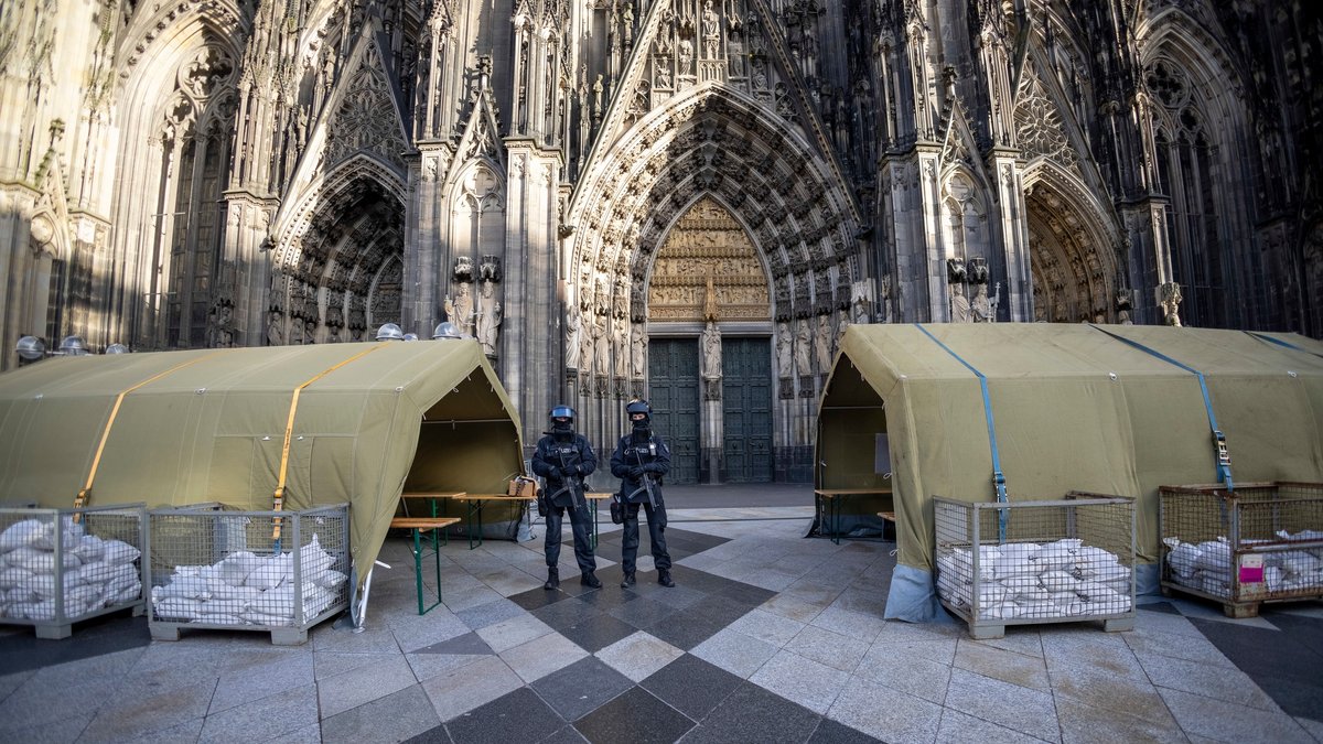 Bewaffnete stehen am Silvestertag 2023 vor dem Kölner Dom