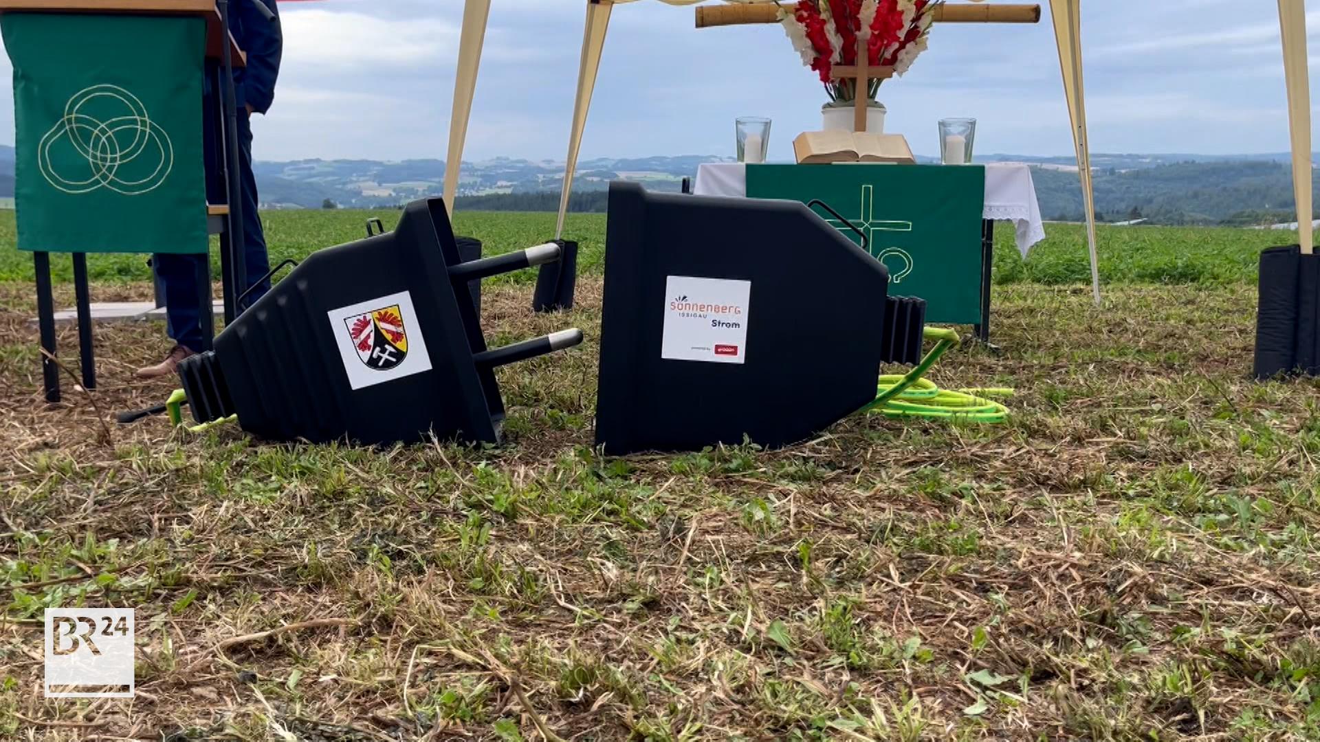 Auf einem Feld liegt ein überdimensional großer Elektrostecker.